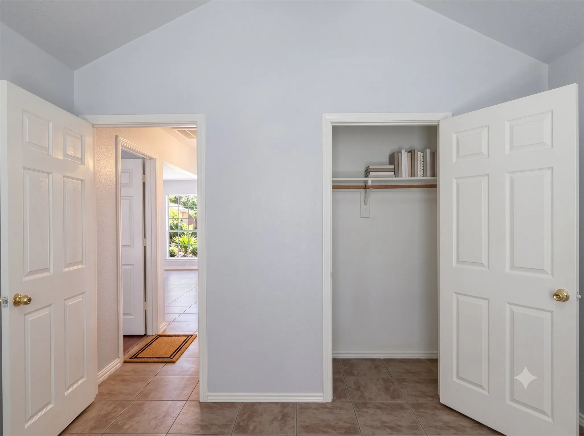 Vaulted ceiling, two six-panel interior doors, and a closet with shelving