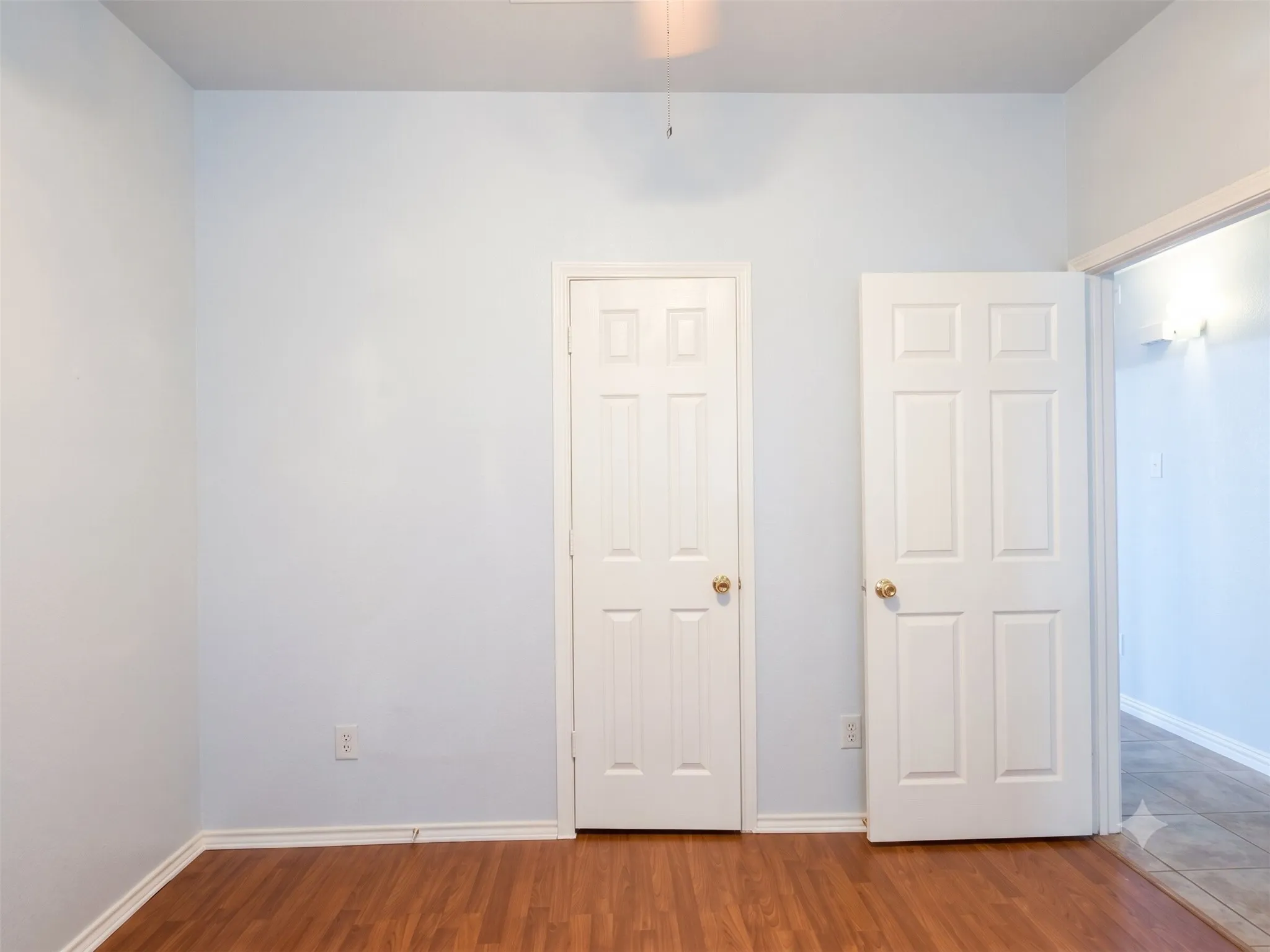 Wood-finish flooring with light-colored walls and white trim