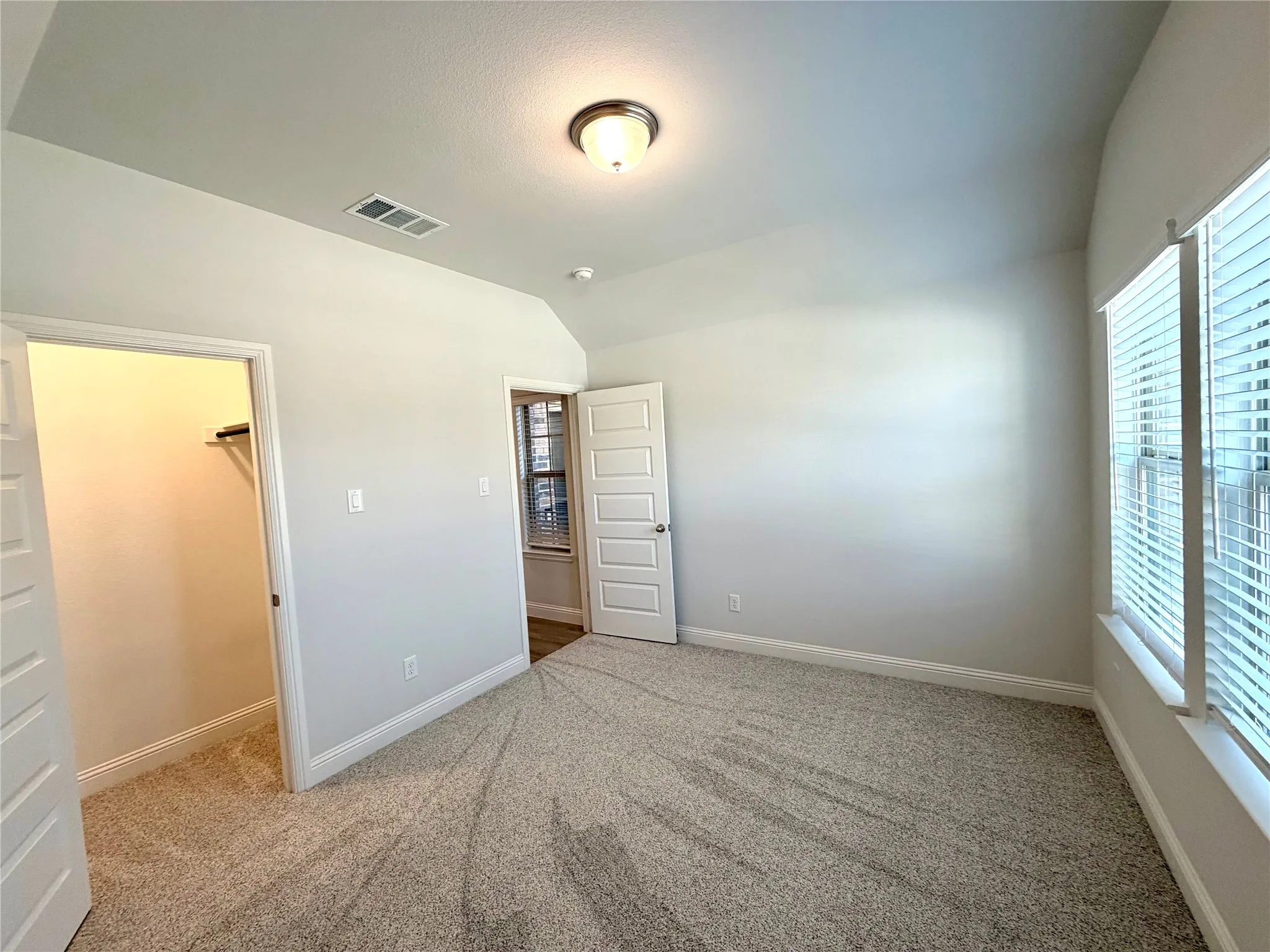 Another view of the front secondary bedroom featuring a walk in closet.