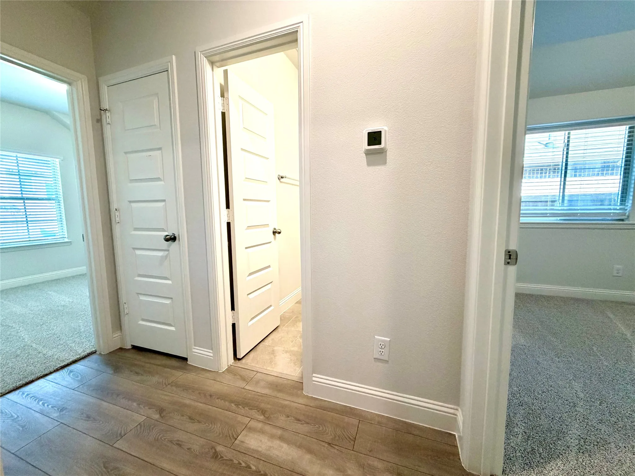 This spacious and well-lit hallway is conveniently located just off the main entry, providing seamless and easy access to two comfortable secondary bedrooms as well as a full, well-appointed shared bathroom.