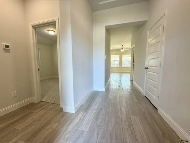 An inviting and spacious entry hall, which features durable luxury vinyl plank (LVP) flooring installed throughout the main living areas, creating a seamless and modern flow, while the attached bedrooms are accented with brand-new, plush carpeting for added comfort and warmth.