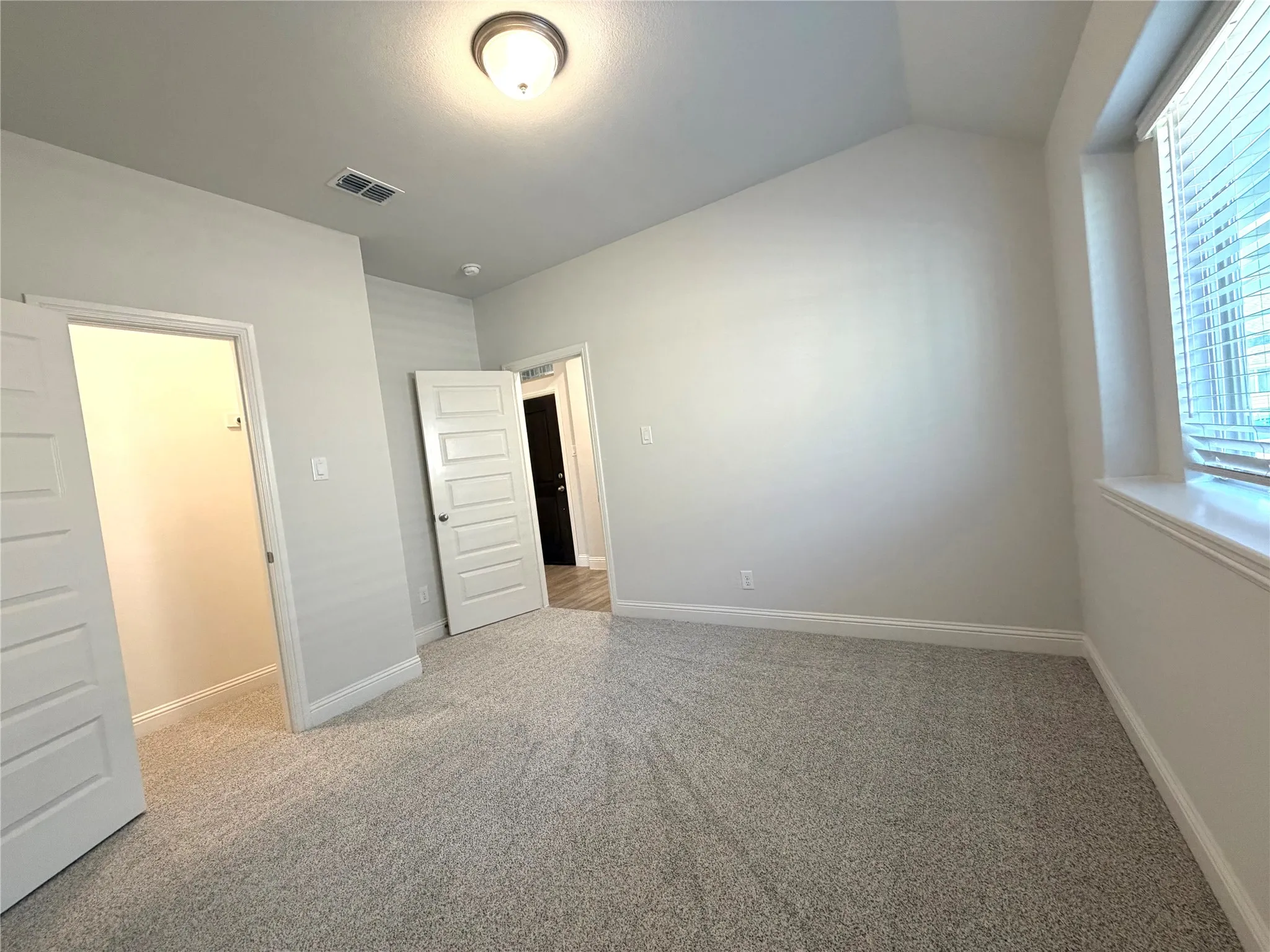 Another view of secondary bedroom 2 with a walk-in closet & a deep window ledge.