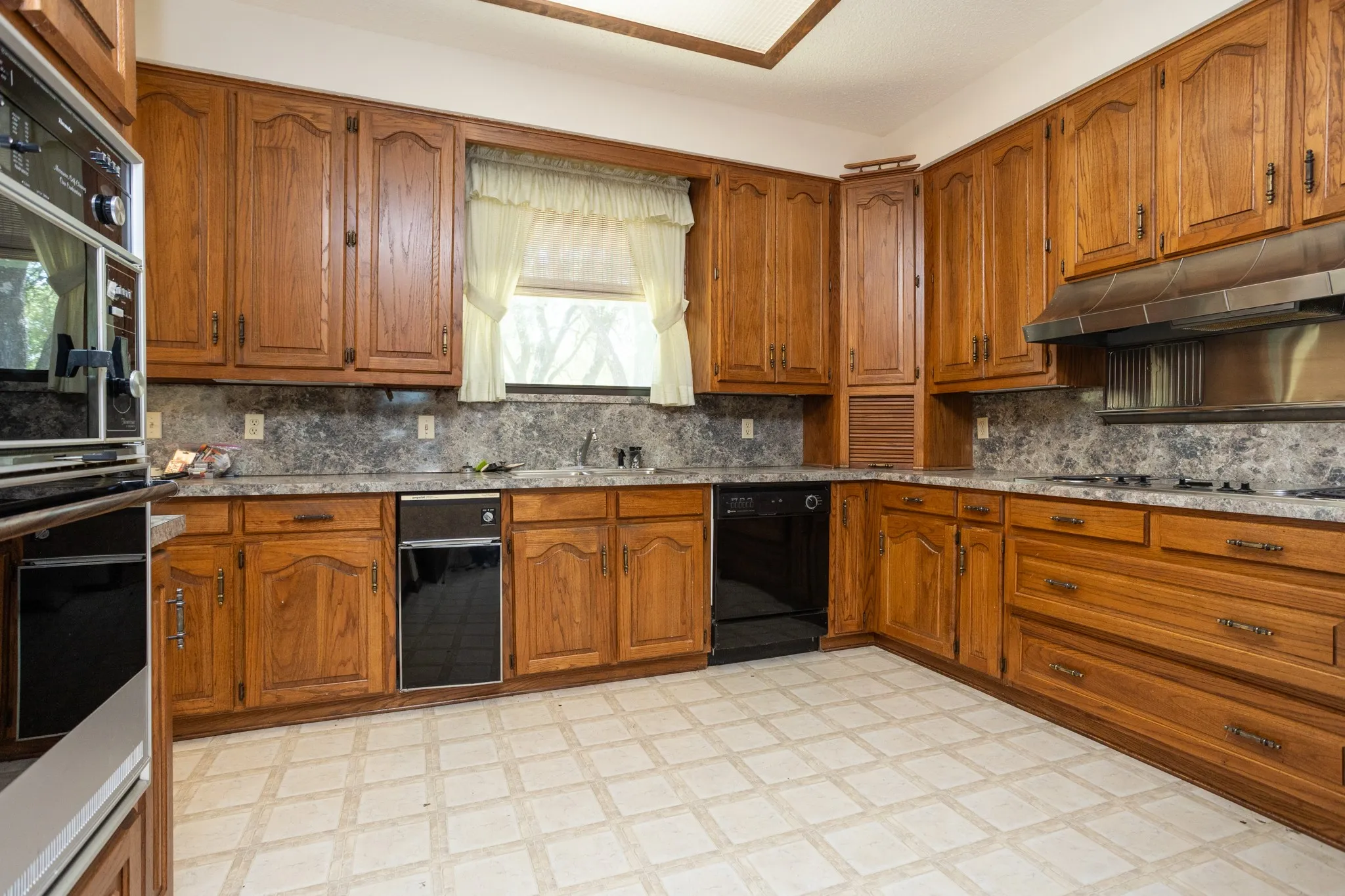 Custom wood cabinets with sink under window.  Appliance garage for your small items.