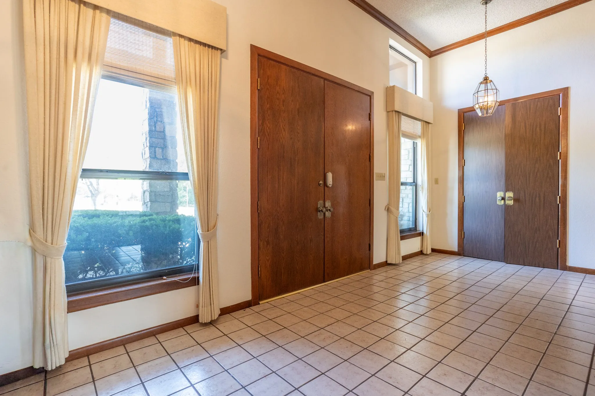 Grand entry with tall doors and closets on each side.