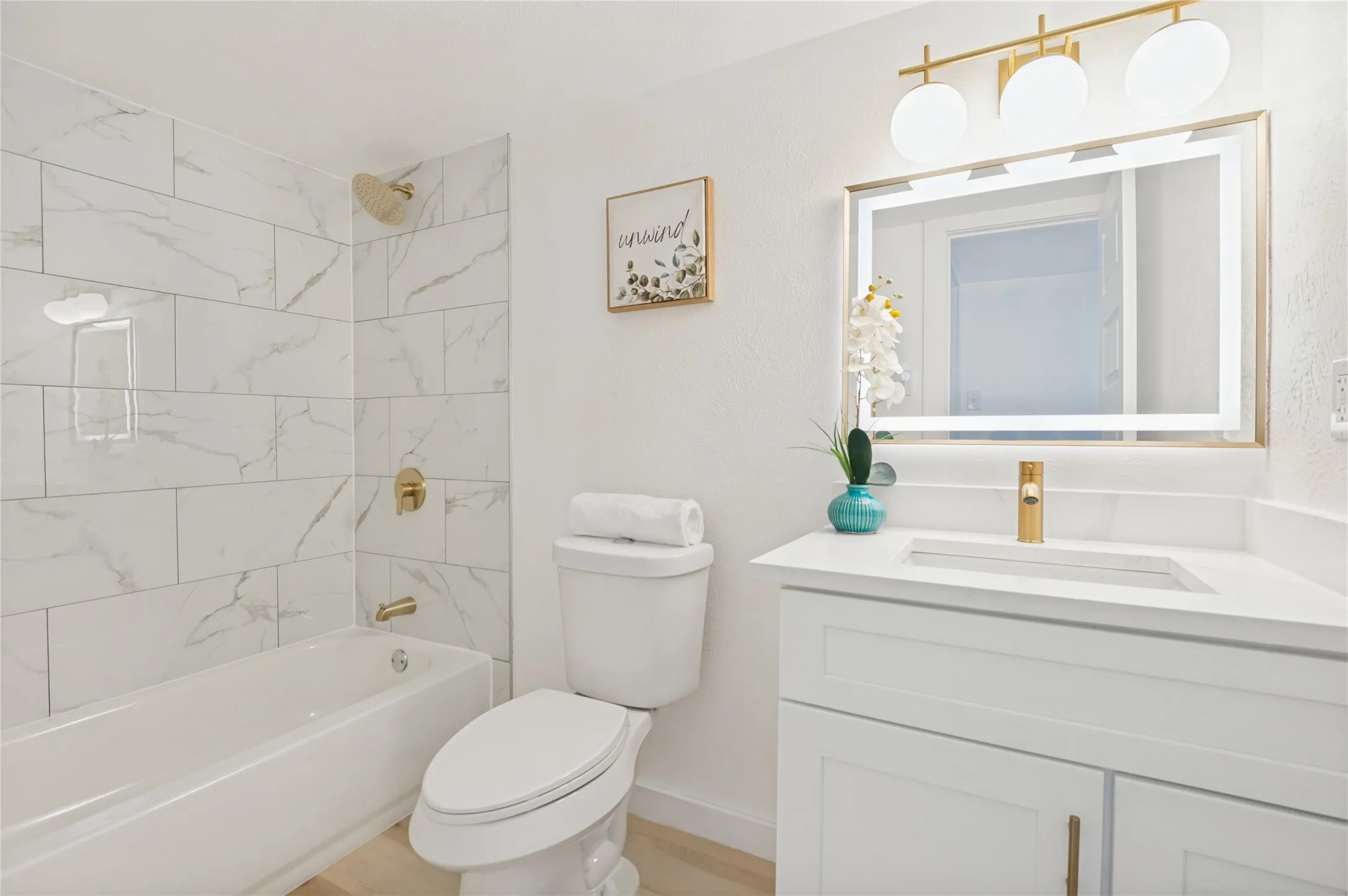 White vanity with a quartz countertop and integrated sink