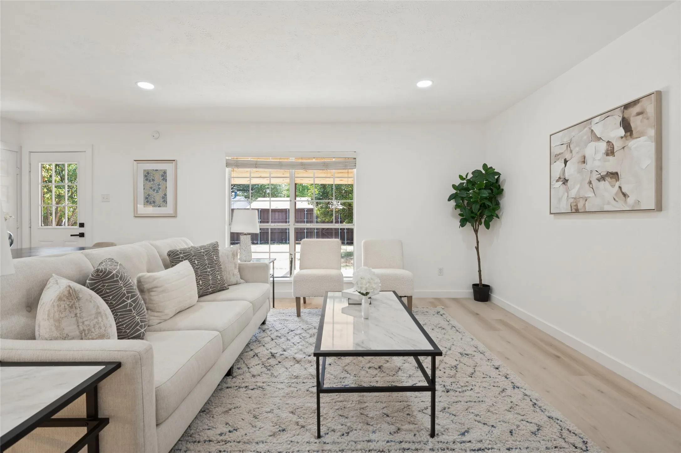 Recessed lighting, wood-finish flooring, and a large window with natural light