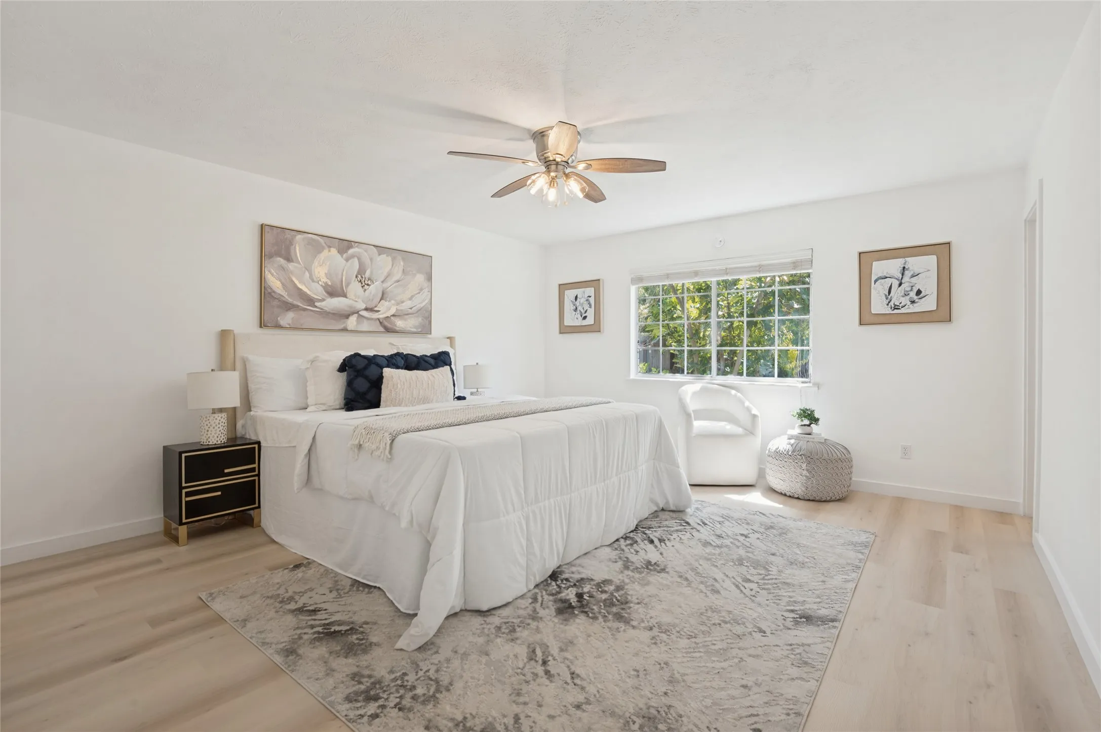 White walls, wood-finish flooring, and a ceiling fan