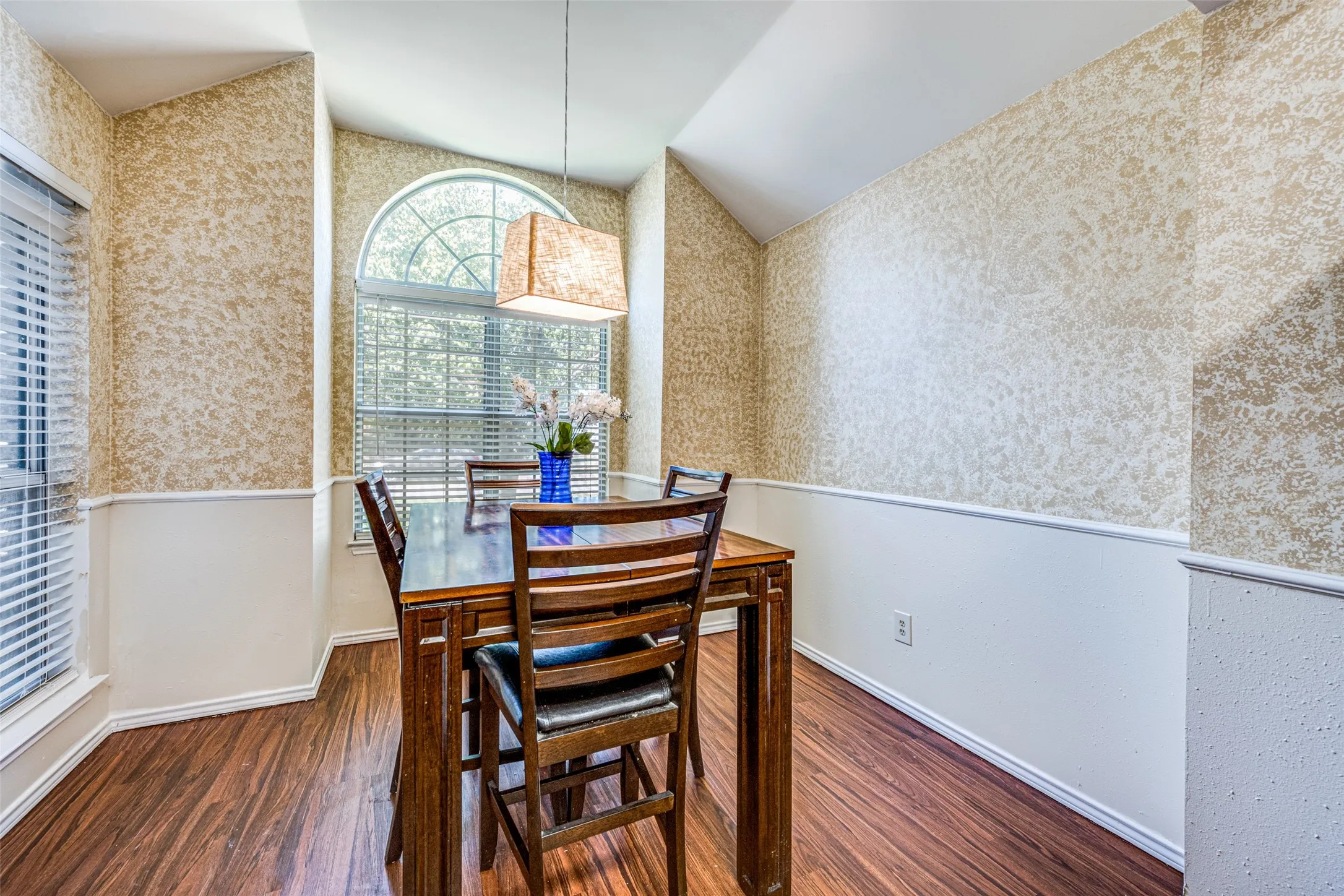 Wood-finish flooring, wainscoting, and textured wall coverings enhance this space