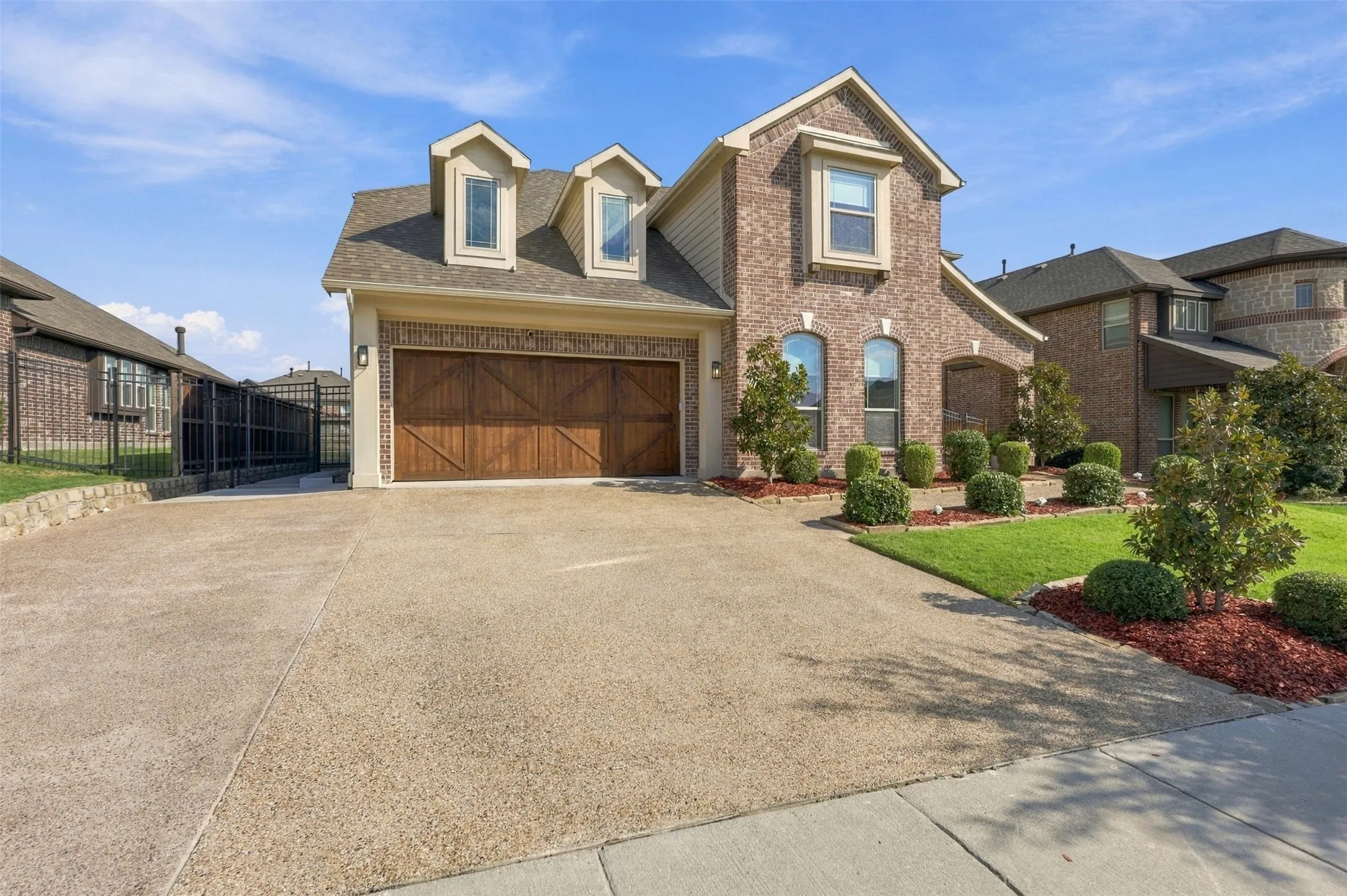 Two car garage with expanded driveway for extra parking and added concrete walkway on side of house to backyard