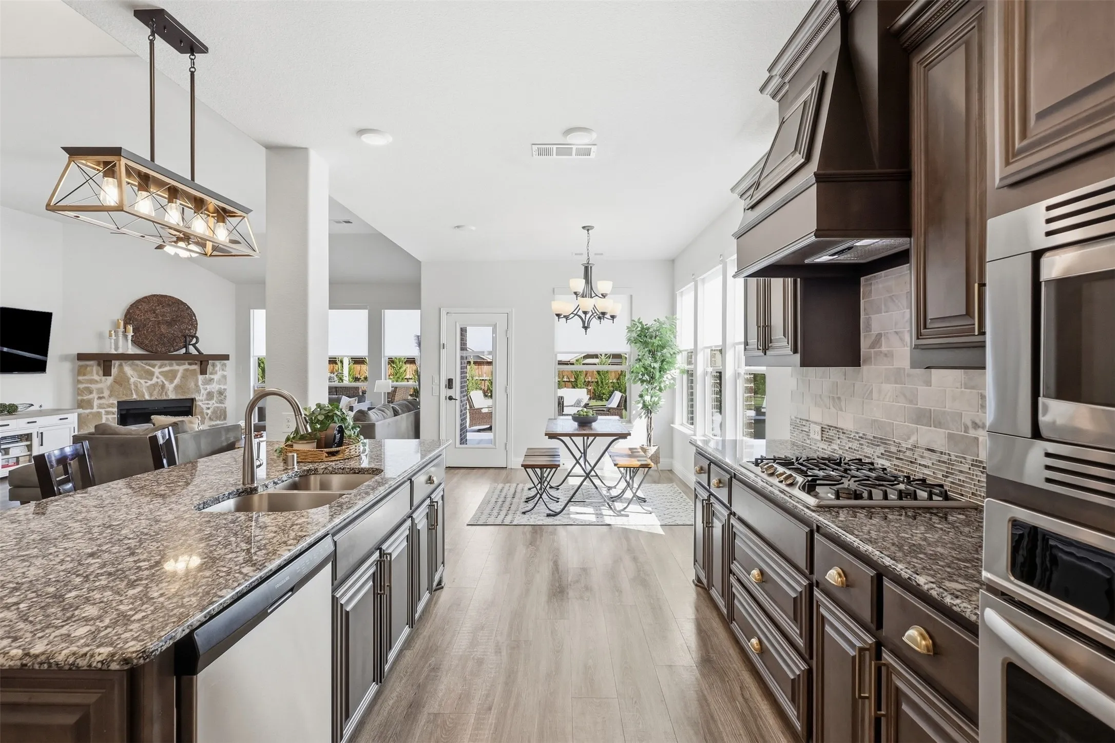 Gourmet kitchen featuring granite countertops, dark wood cabinetry, stainless steel appliances and gas range