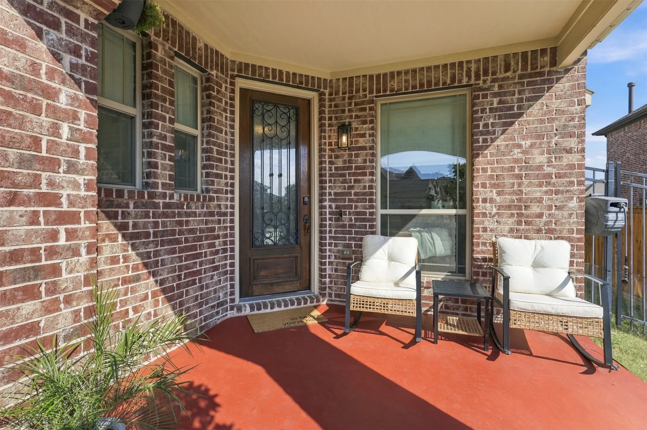 Cozy covered from porch with updated wood door with iron work