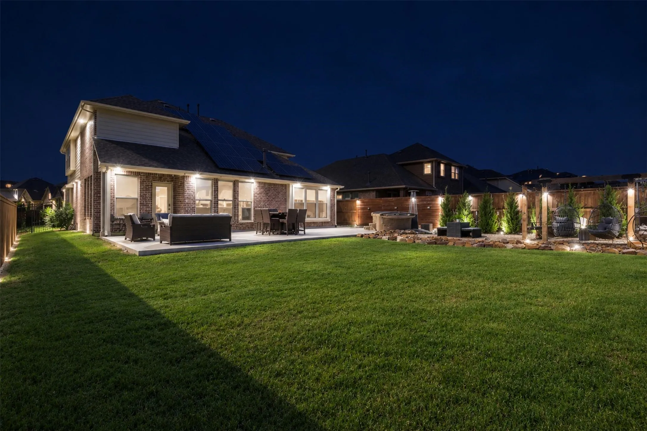 View of the backyard in the evening with all the LED track lighting system