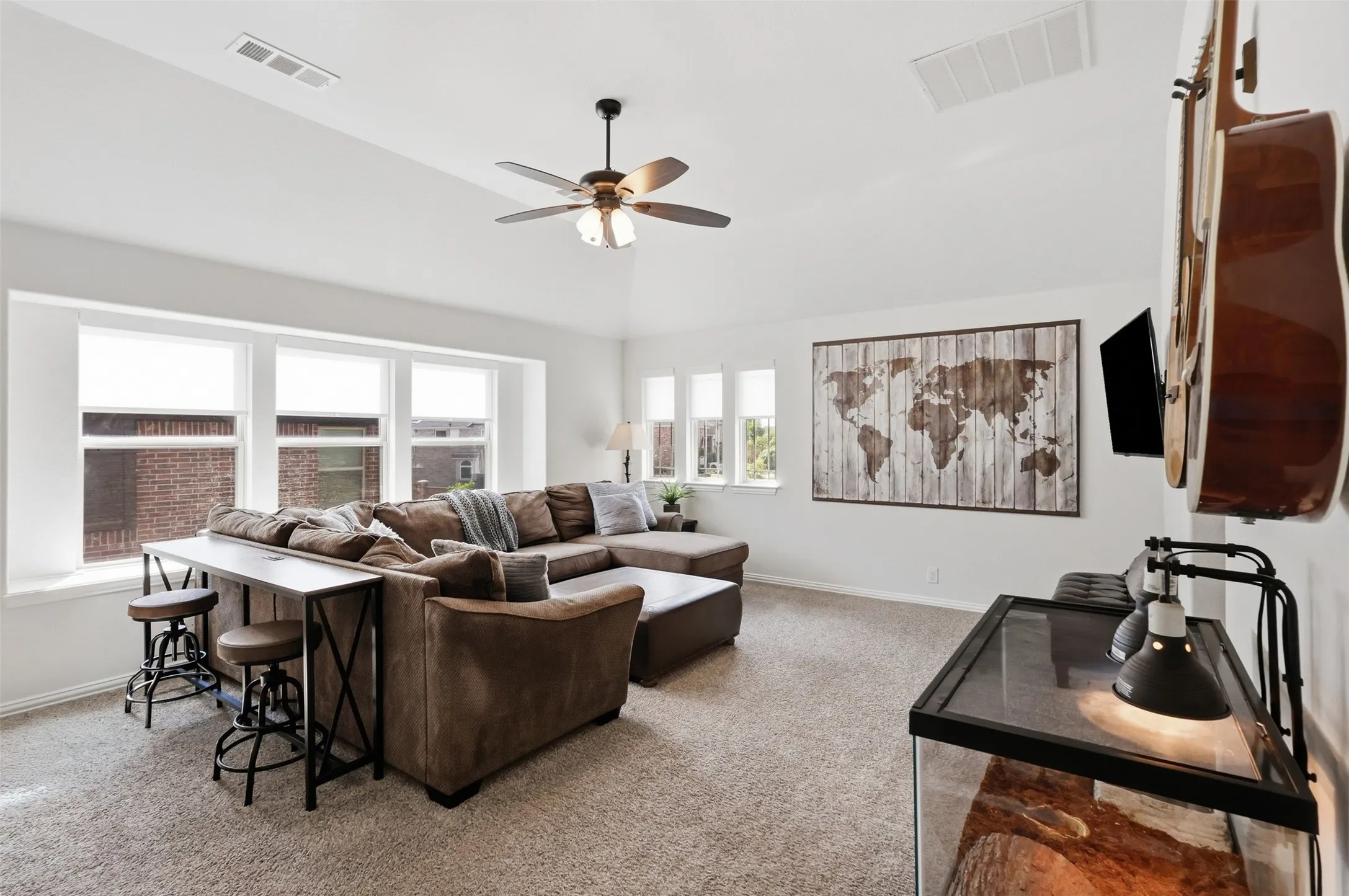 Upstairs living space with vaulted ceiling and windows surround