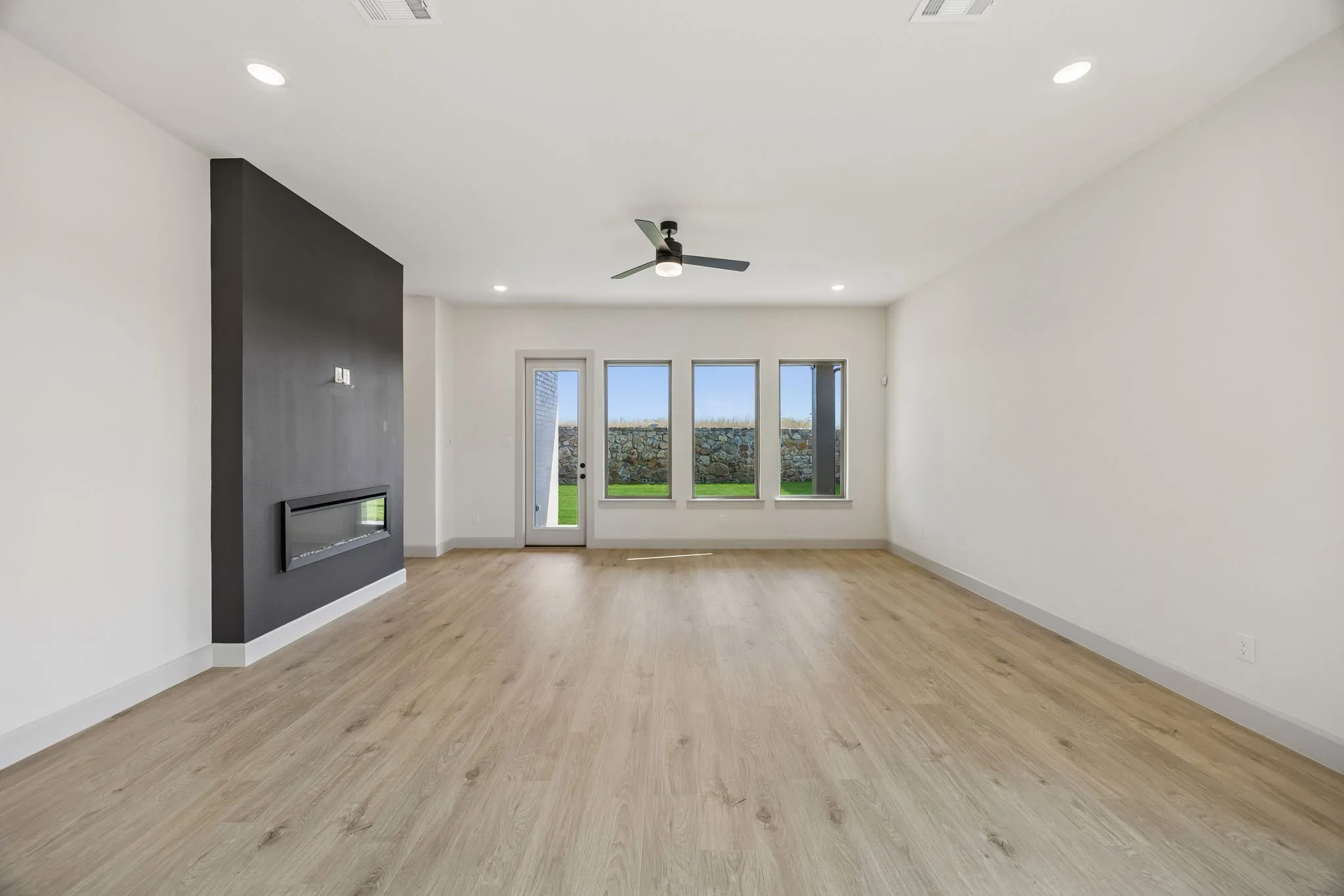 Memories are waiting to be made in this spacious family room featuring a striking fireplace wall!