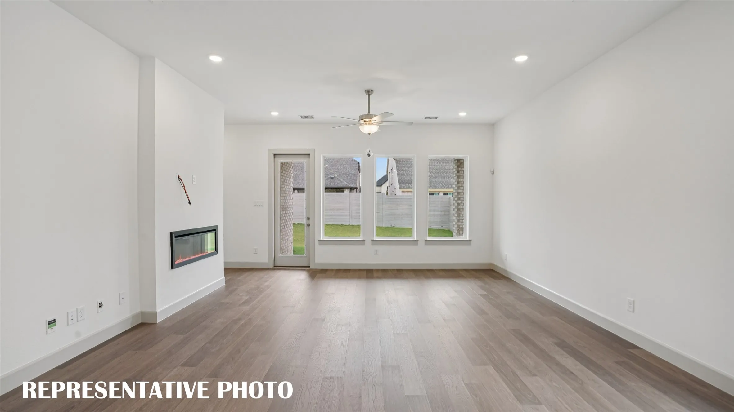 Featuring a wall of windows overlooking the back yard, this family room is where memories will be made!  REPRESENTATIVE PHOTO