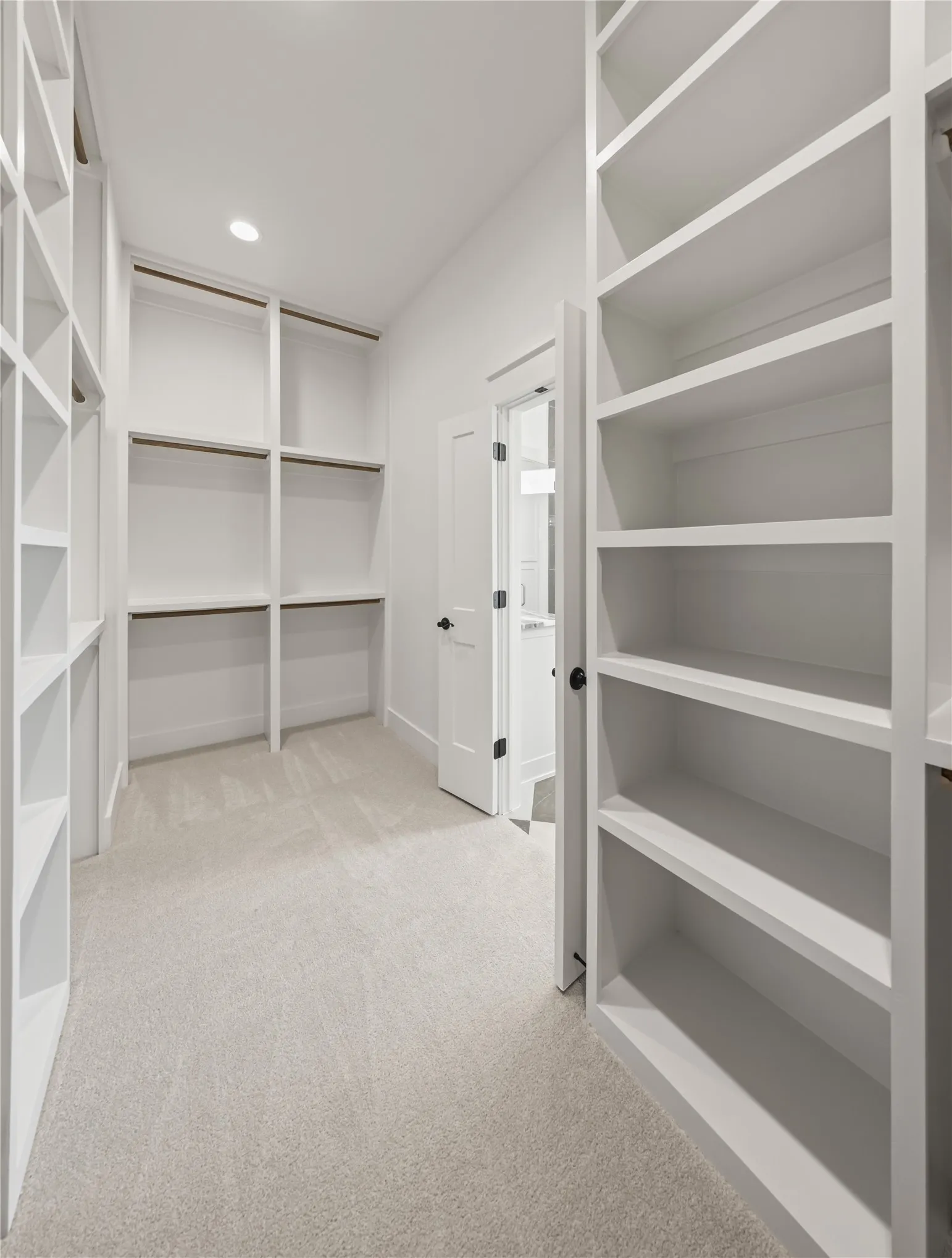 Integrated custom shelving, built-in hanging rods, and recessed ceiling lighting