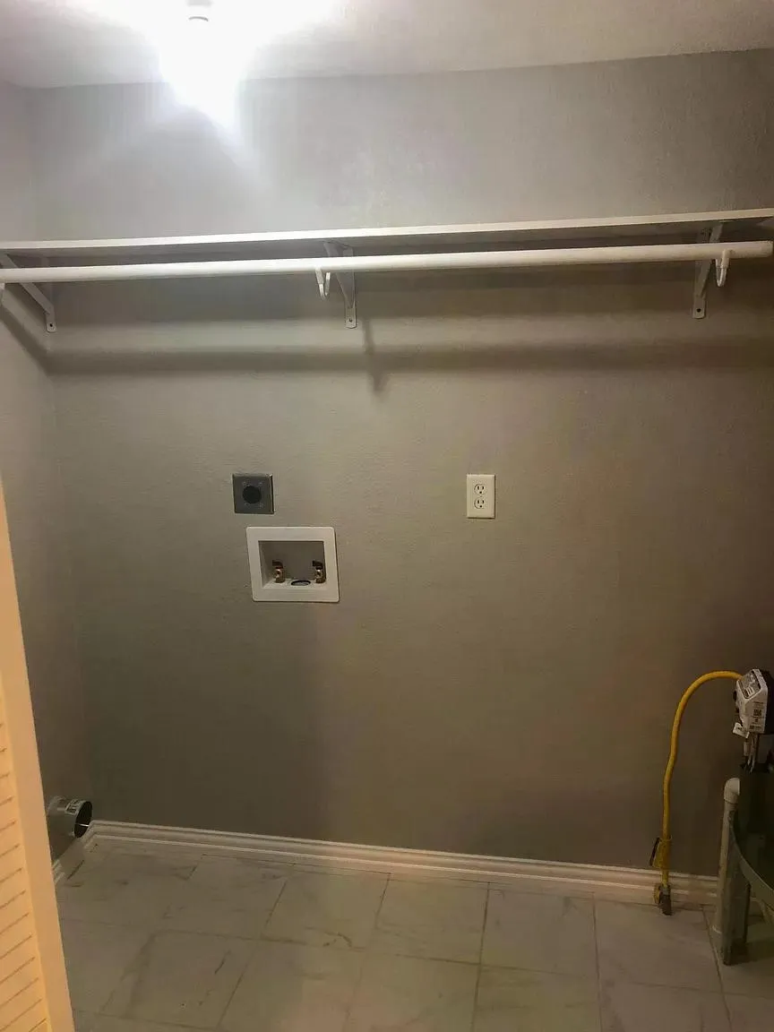 White wire shelving with hanging rod, light grey wall paint, white trim, and light-toned tile flooring