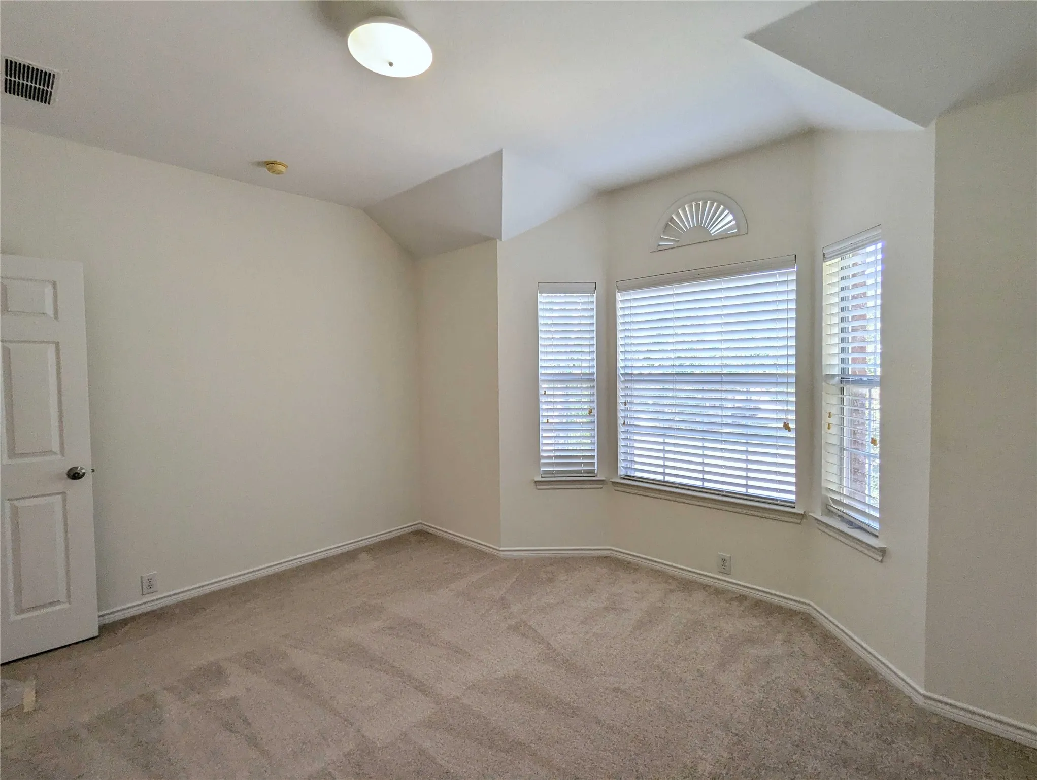 Bay window with multiple window treatments and an arched transom