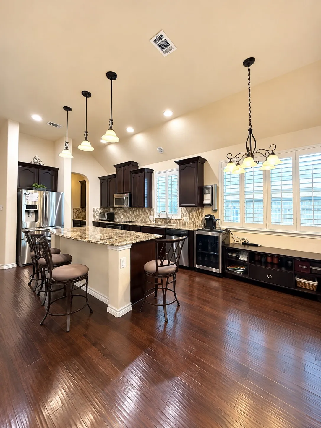 Gourmet kitchen featuring dark cabinetry, granite countertops, stainless steel appliances, and a large center island with​​‌​​​​‌​​‌‌​‌‌​​​‌‌​‌​‌​‌​​​‌​​ seating