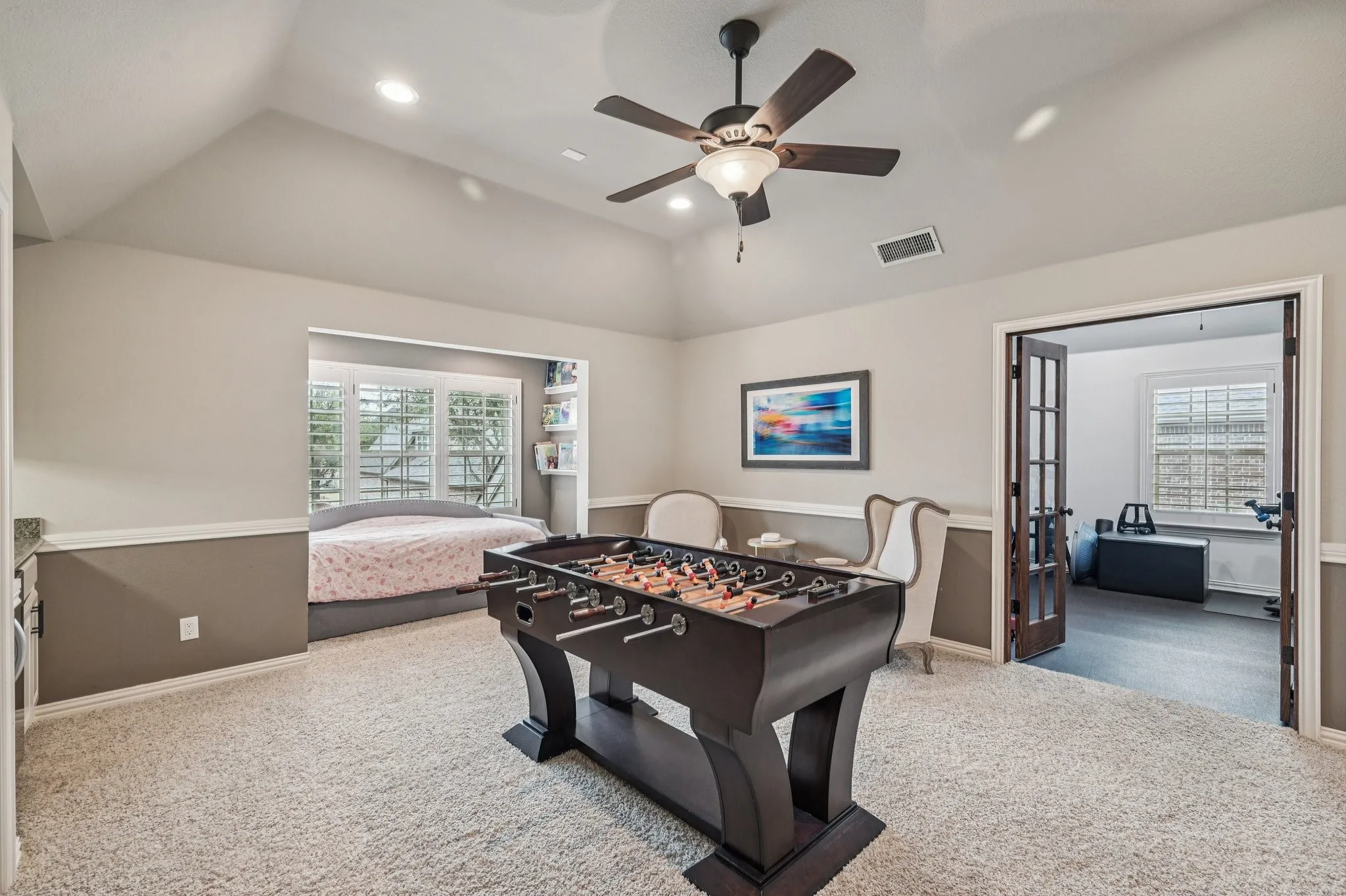 Vaulted ceiling, recessed lighting, ceiling fan, carpet flooring, and a built-in window seating area