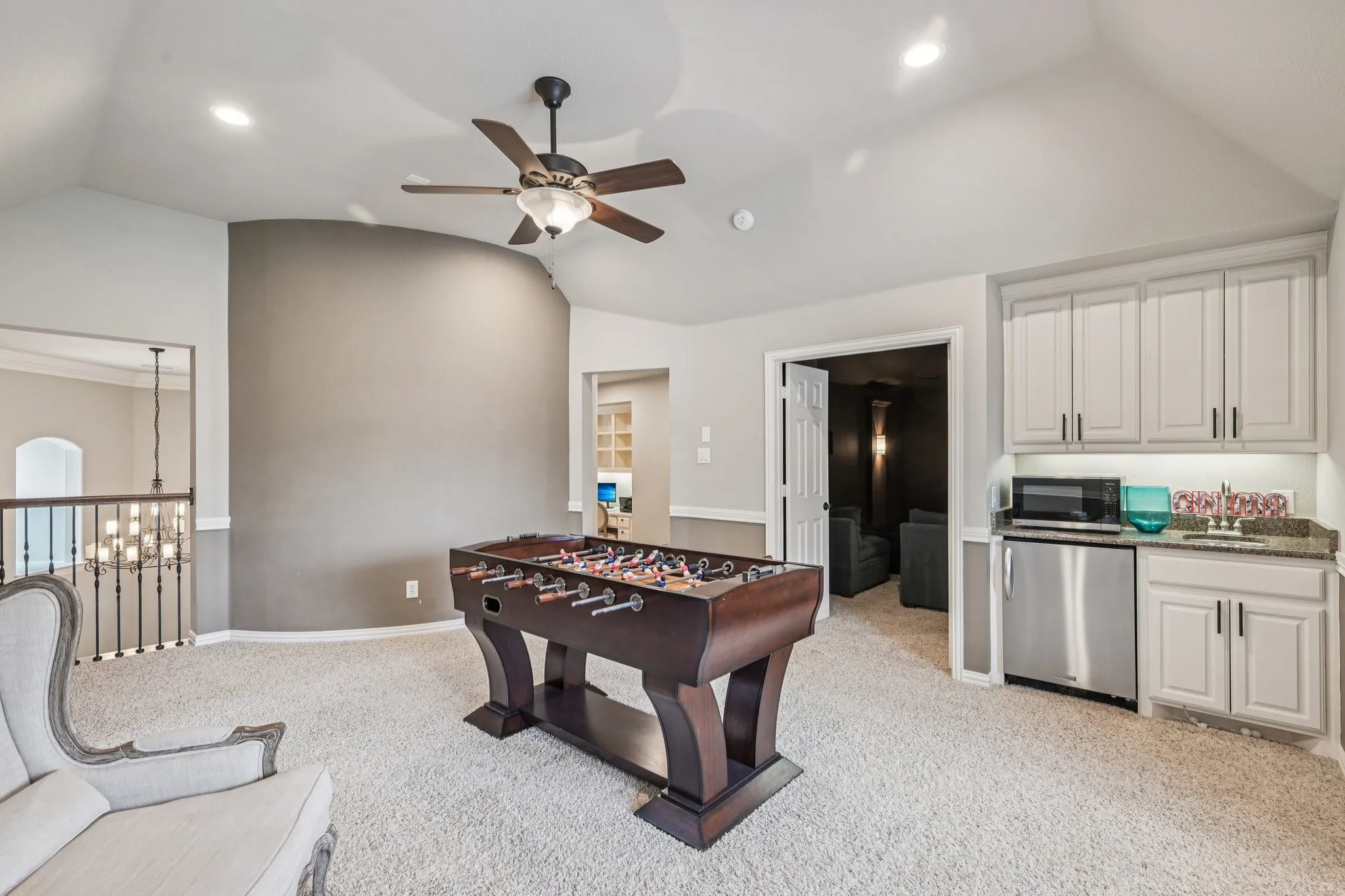 Vaulted ceiling with recessed lighting and a ceiling fan