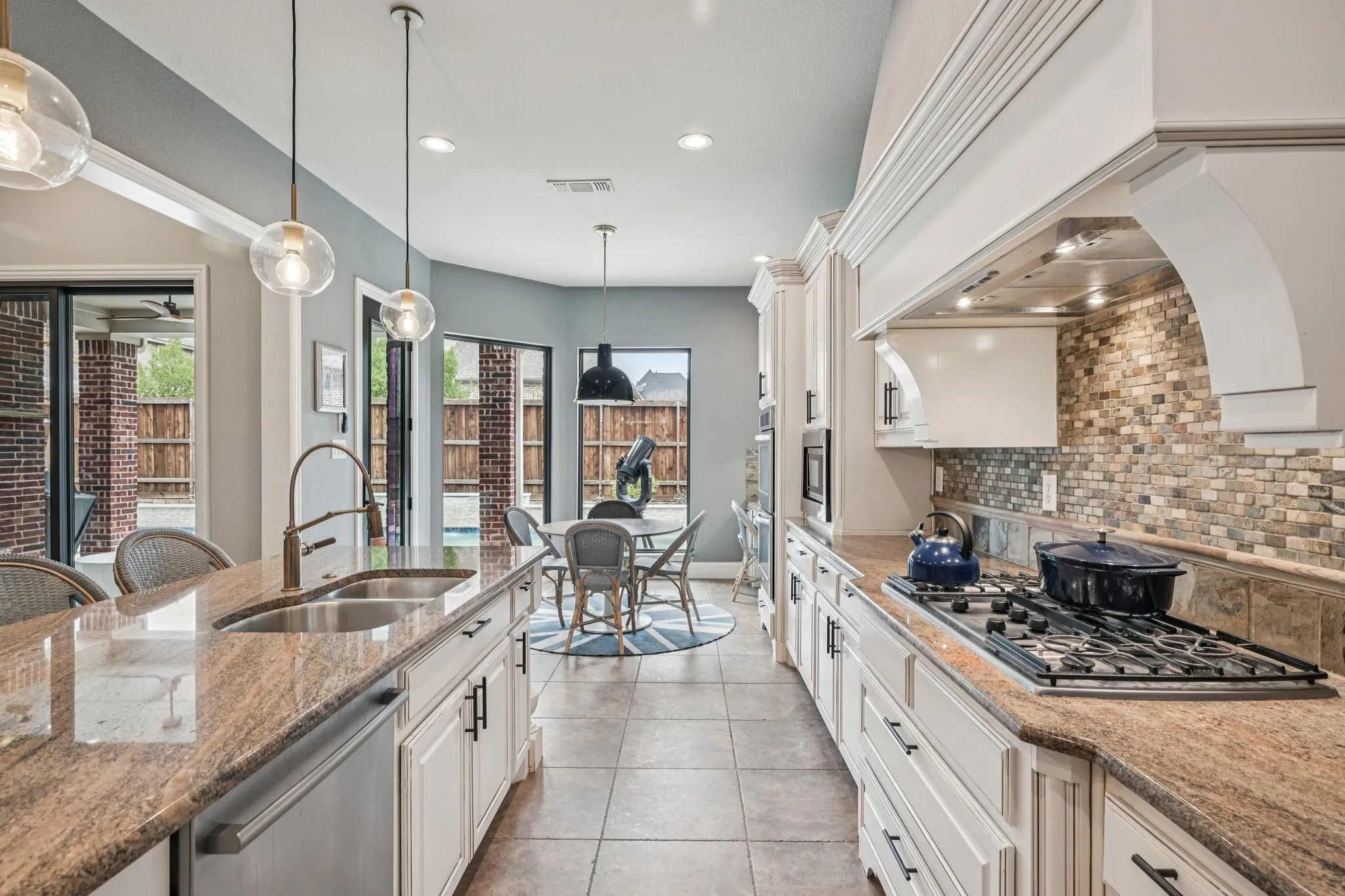 Spacious kitchen featuring a gas range, built-in microwave, integrated dishwasher, and stone countertops