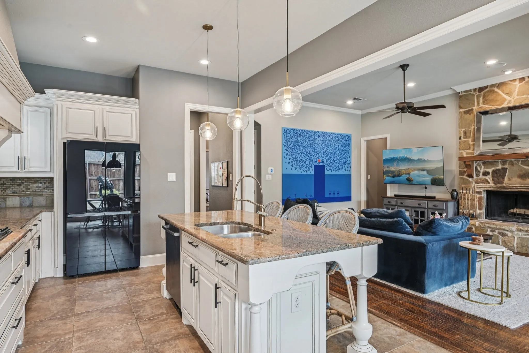 Kitchen island featuring a stainless steel sink and a granite countertop