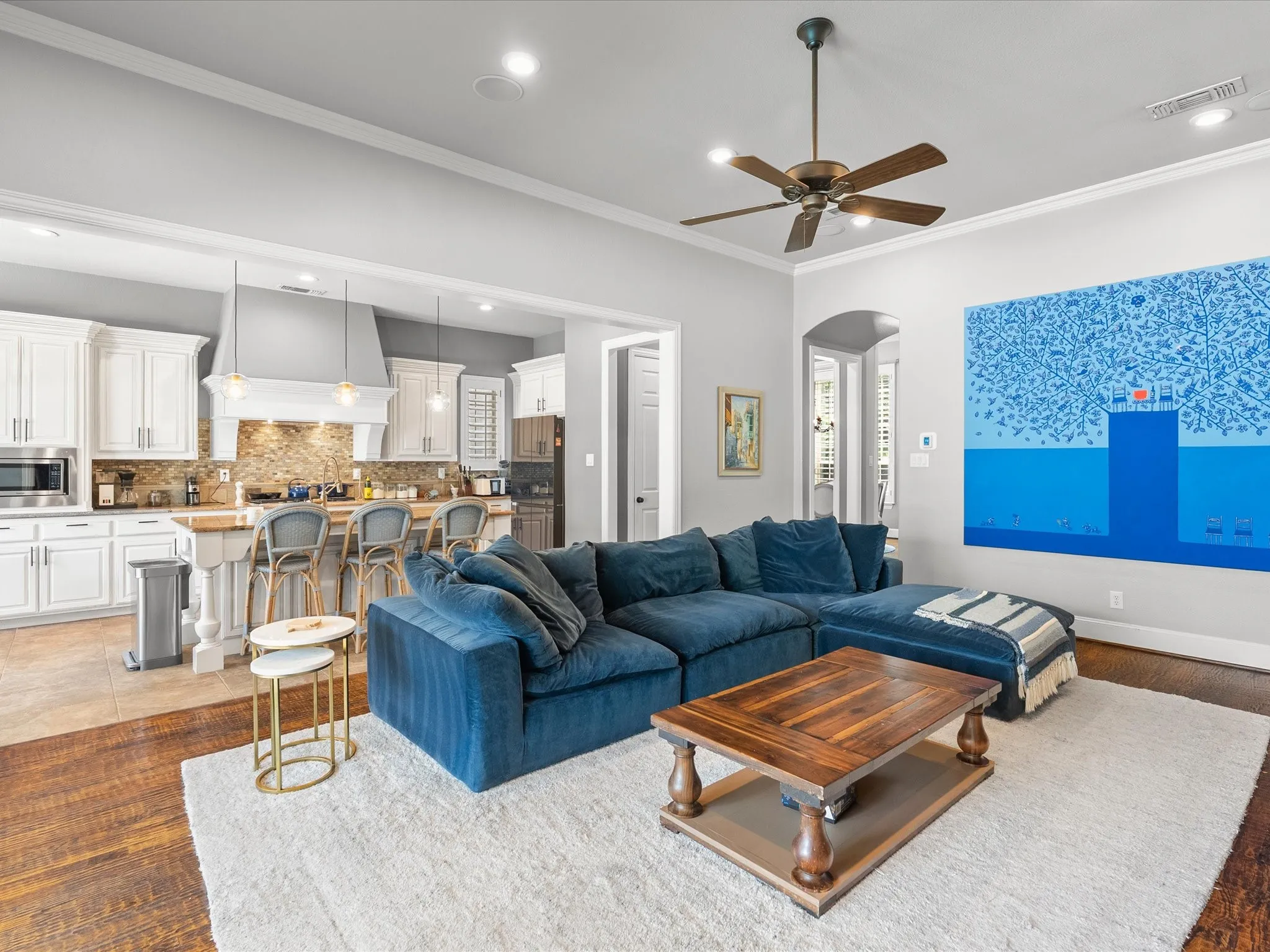 Wood-finish flooring, recessed lighting, crown molding, and a ceiling fan with integrated lighting
