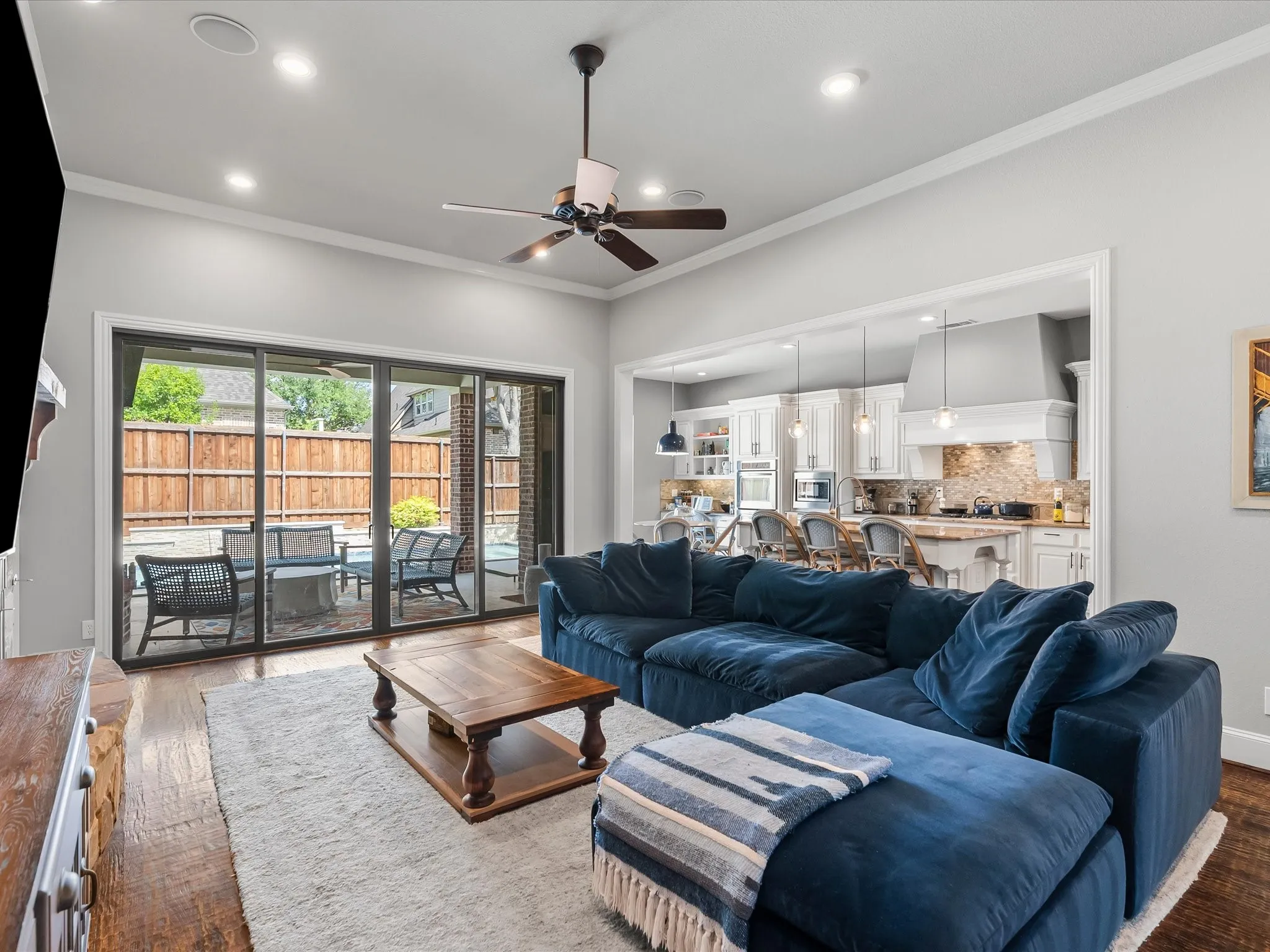 Spacious living area with wood-finish flooring, recessed lighting, and a ceiling fan