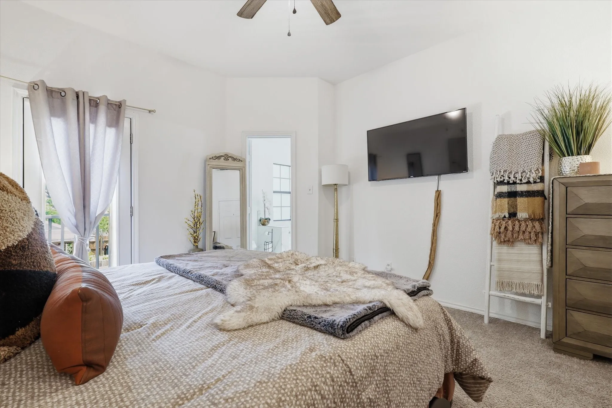 White walls, carpeted flooring, and a ceiling fan