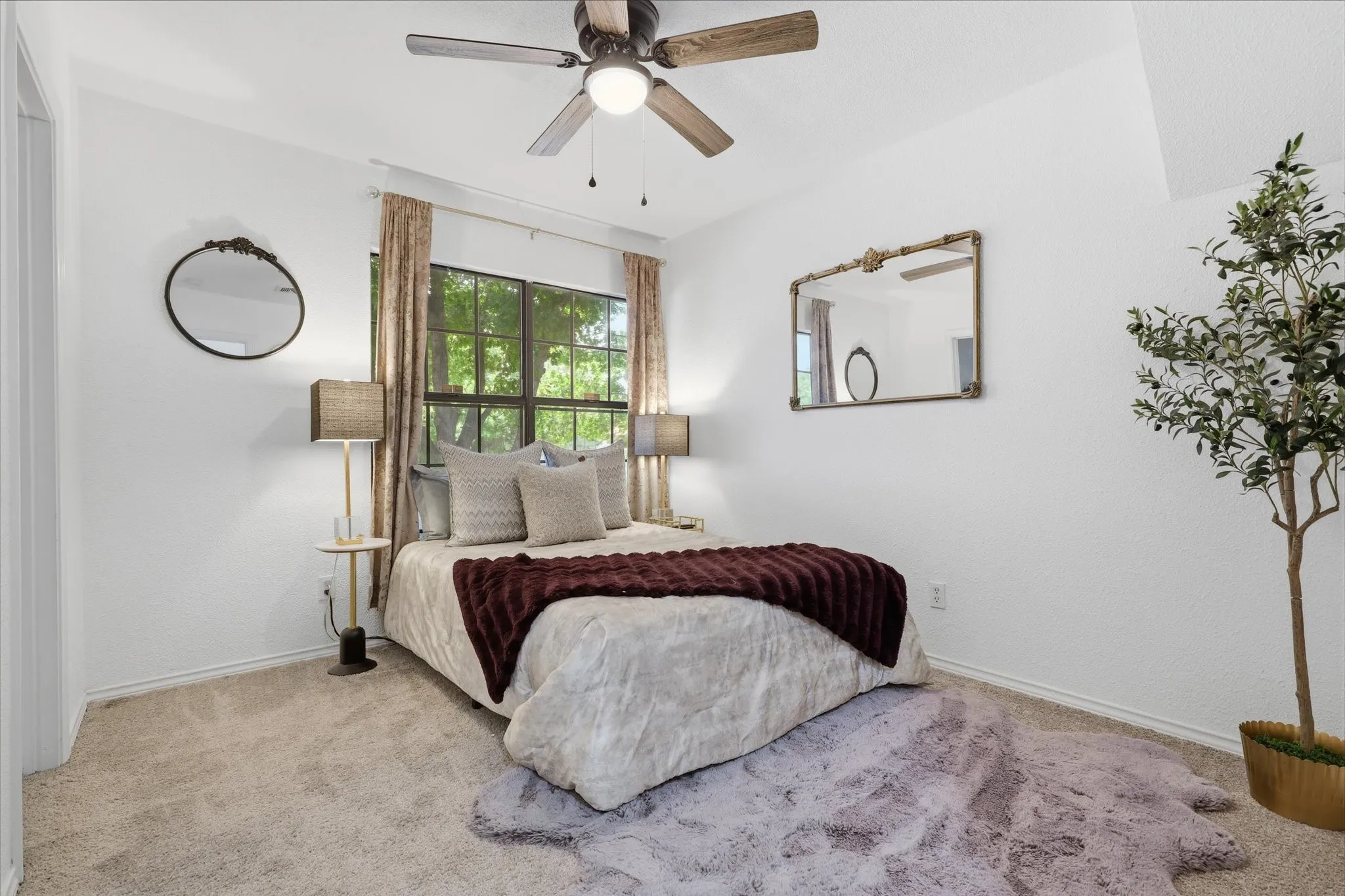Vaulted ceiling with a ceiling fan, carpeted flooring, large window, and light-toned wall finishes