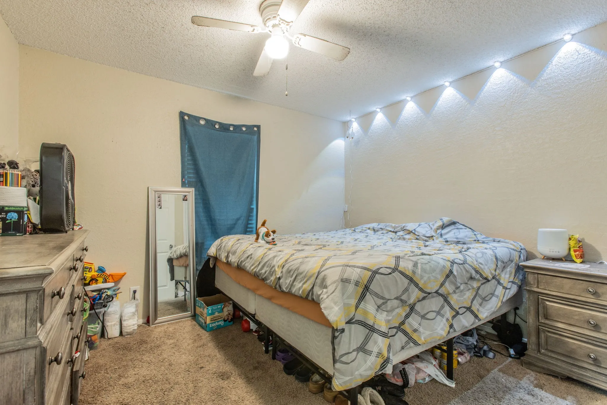 Textured walls with overhead lighting and a ceiling fan