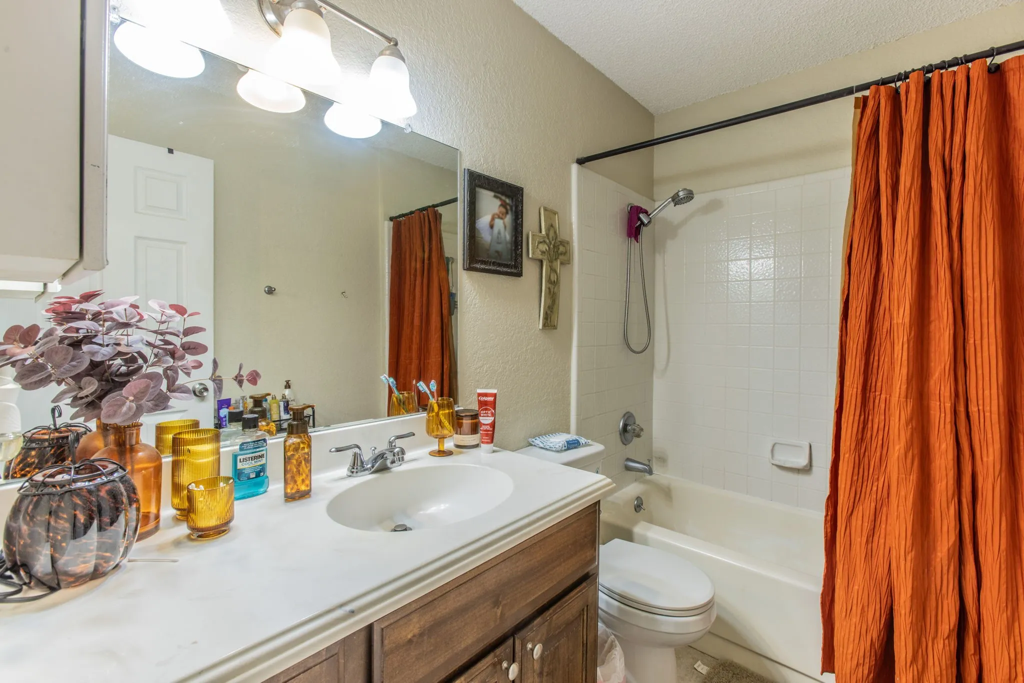 Vanity with a single basin sink, chrome faucet, and a large mirror
