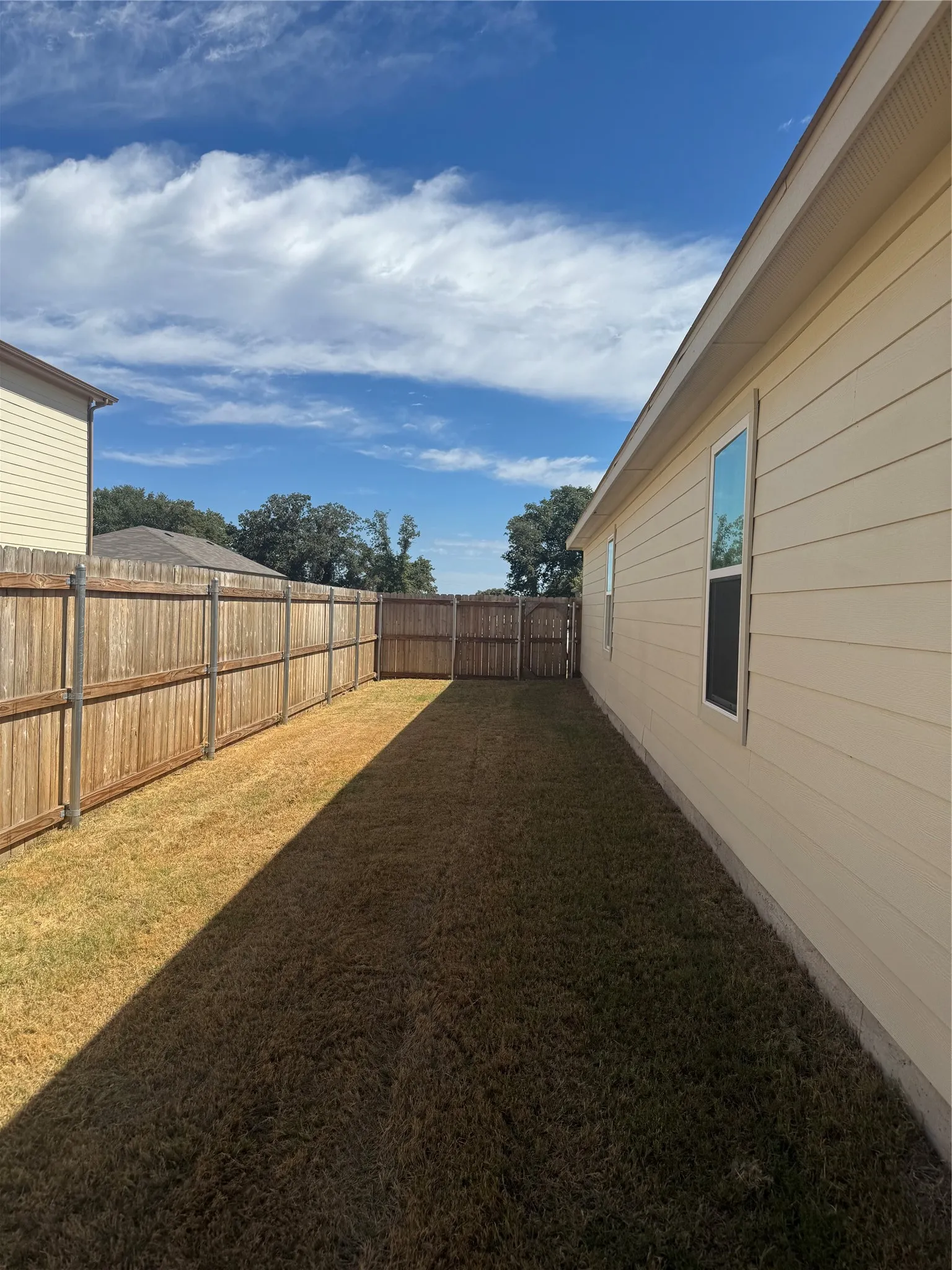 Fenced backyard featuring a manicured lawn
