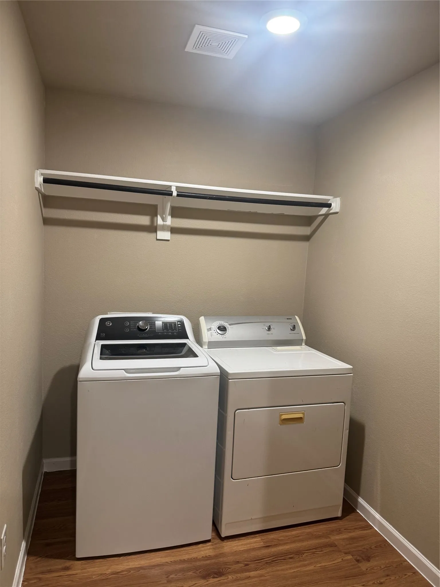 Laundry area featuring wood-finish flooring, built-in shelving, recessed ceiling lighting, and a ceiling ventilation fan
