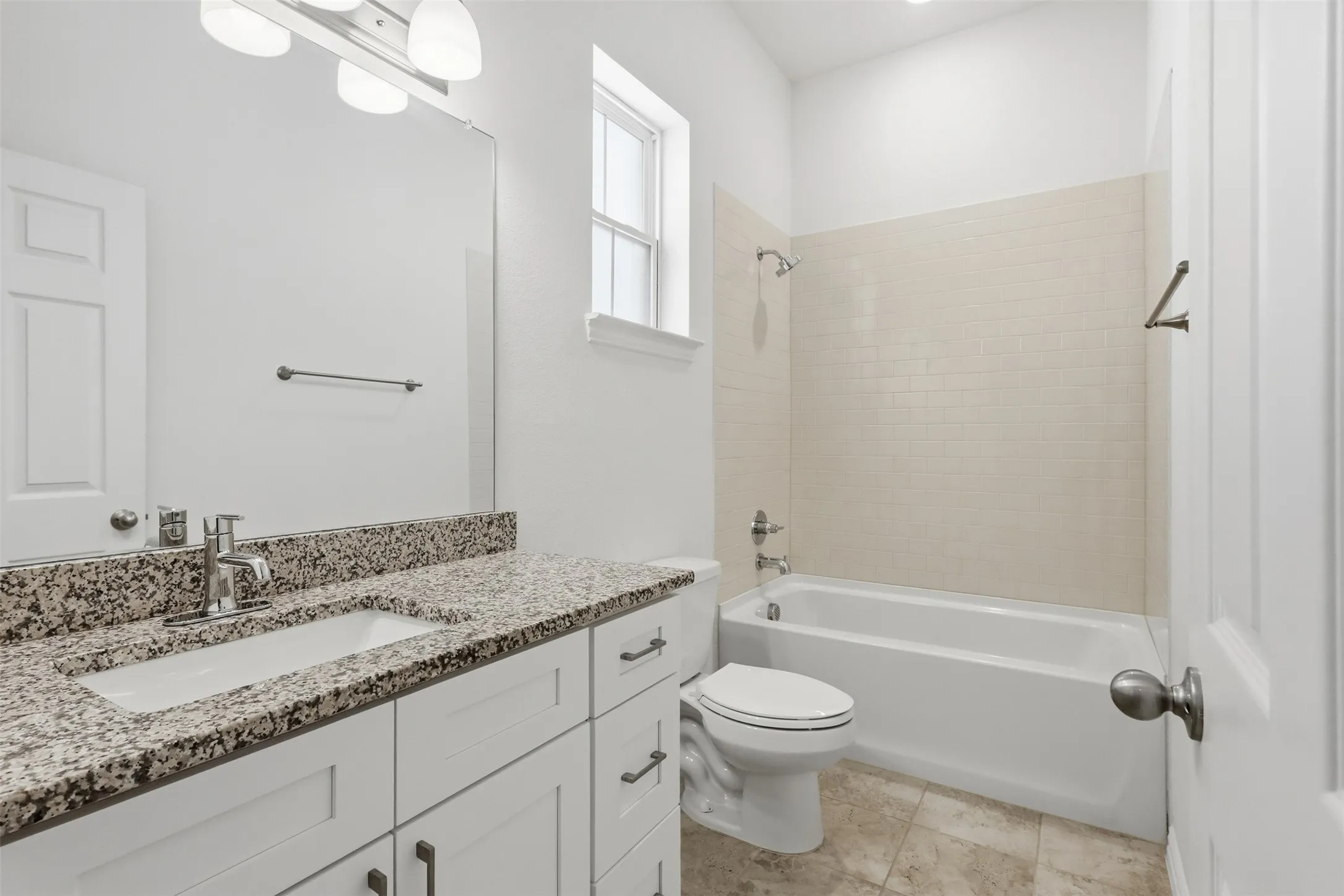 Spacious vanity with granite countertop, integrated sink, and white cabinetry
