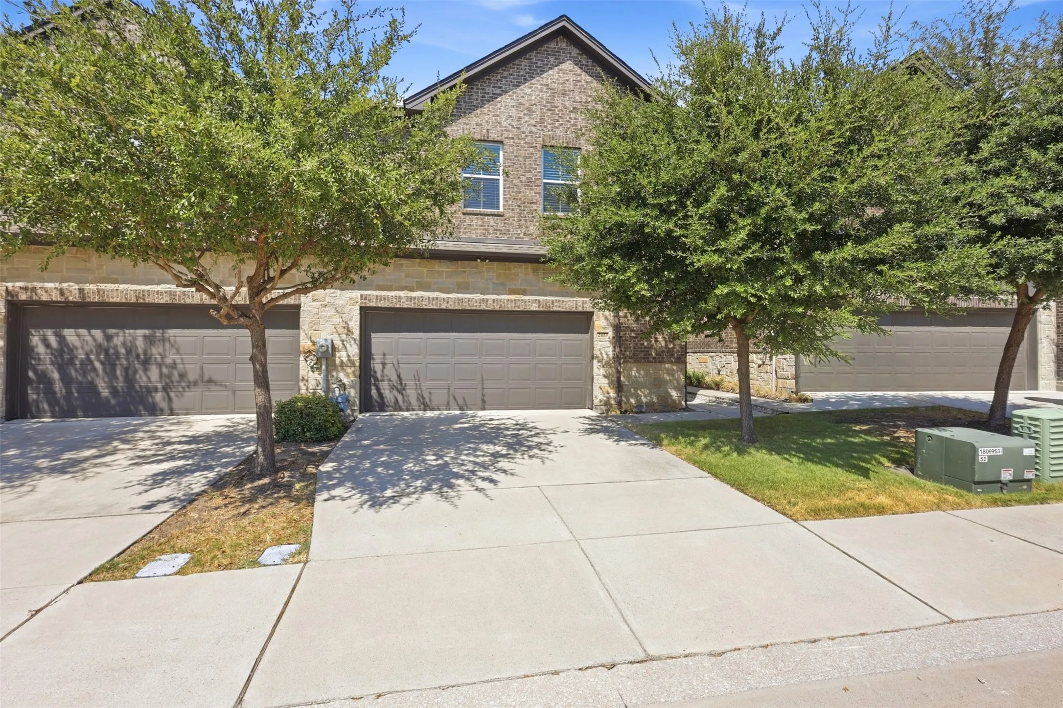 Brick exterior with stone accents and multiple garage doors