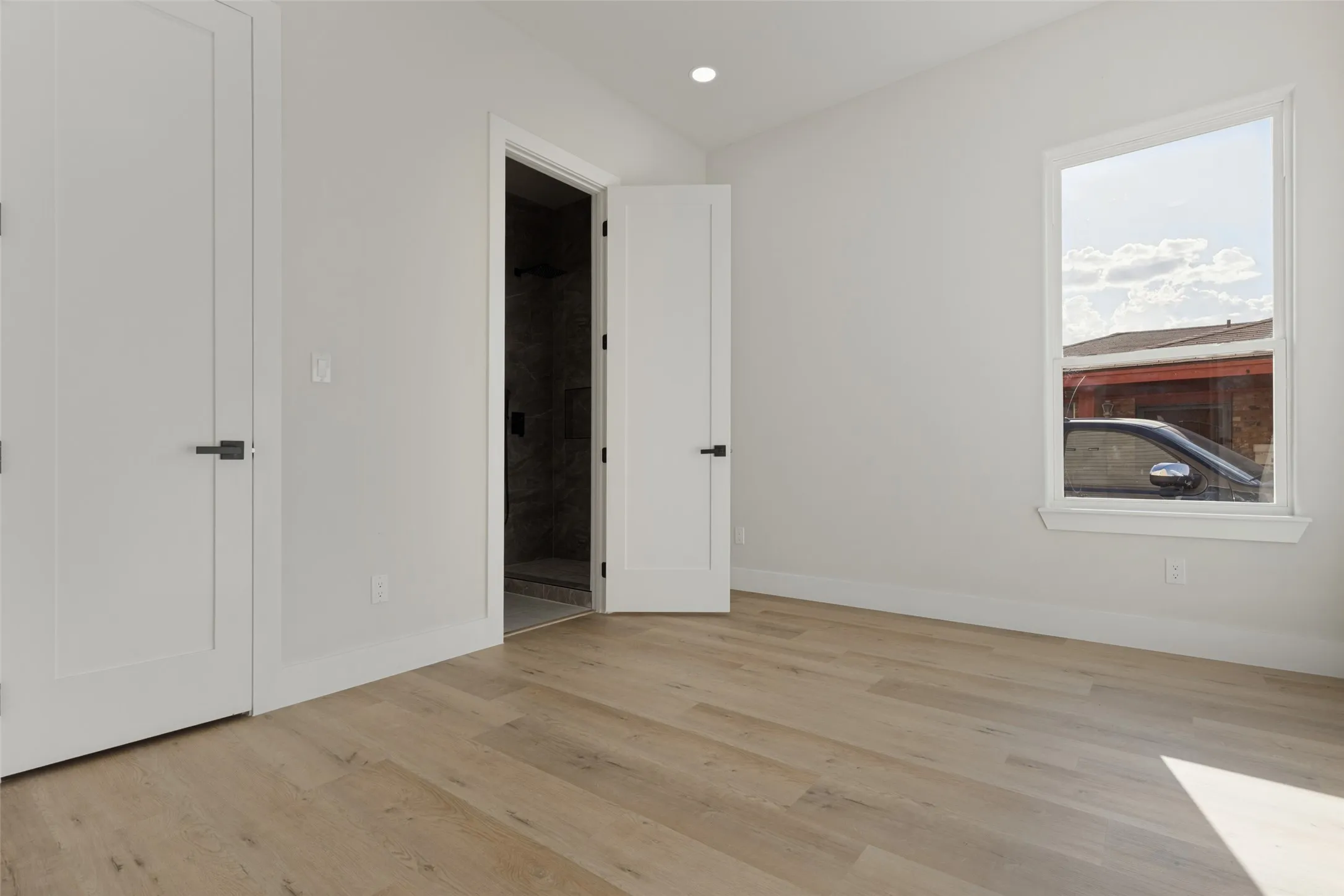 Light wood-finish flooring with white walls and trim