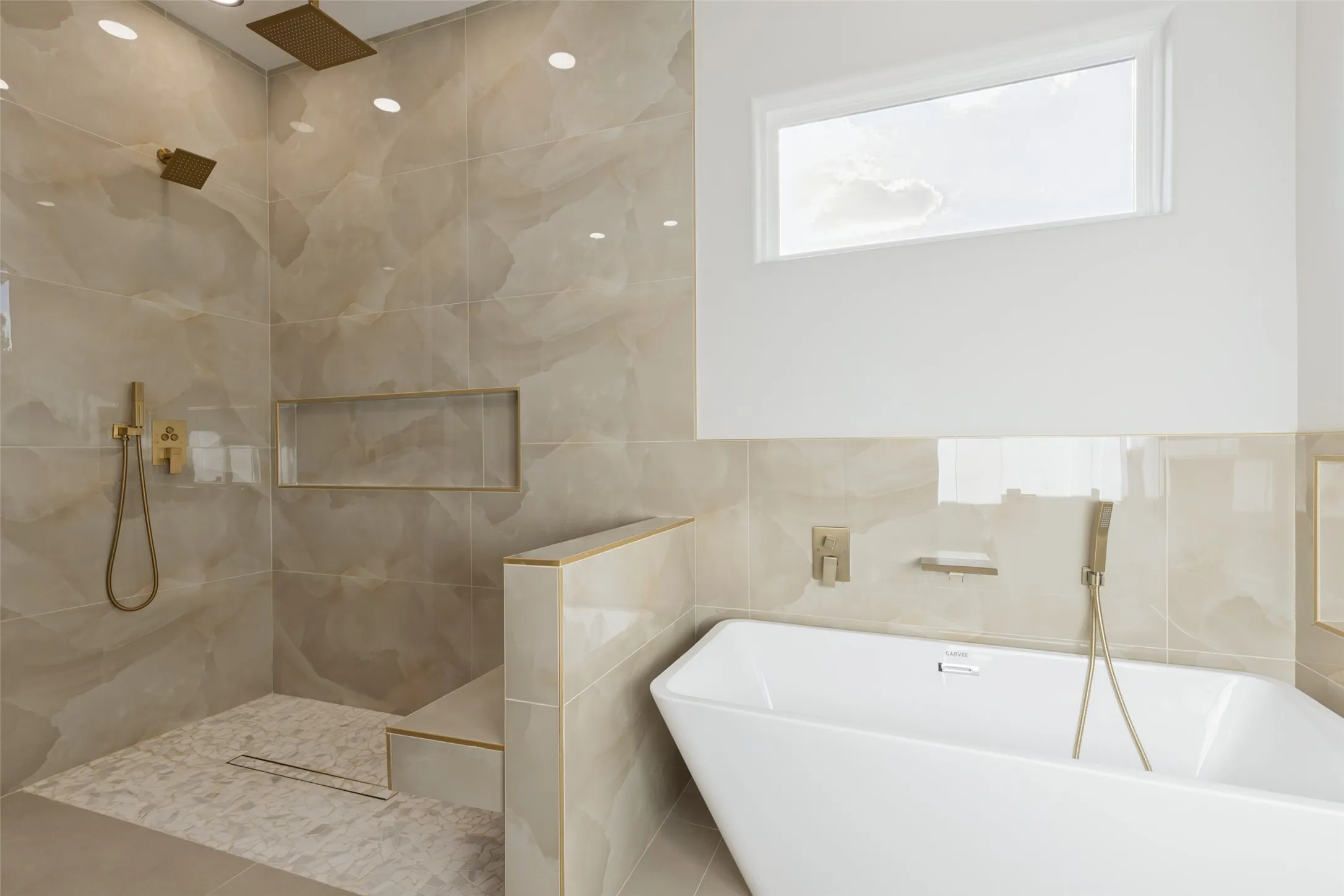 Freestanding soaking tub with gold-tone fixtures