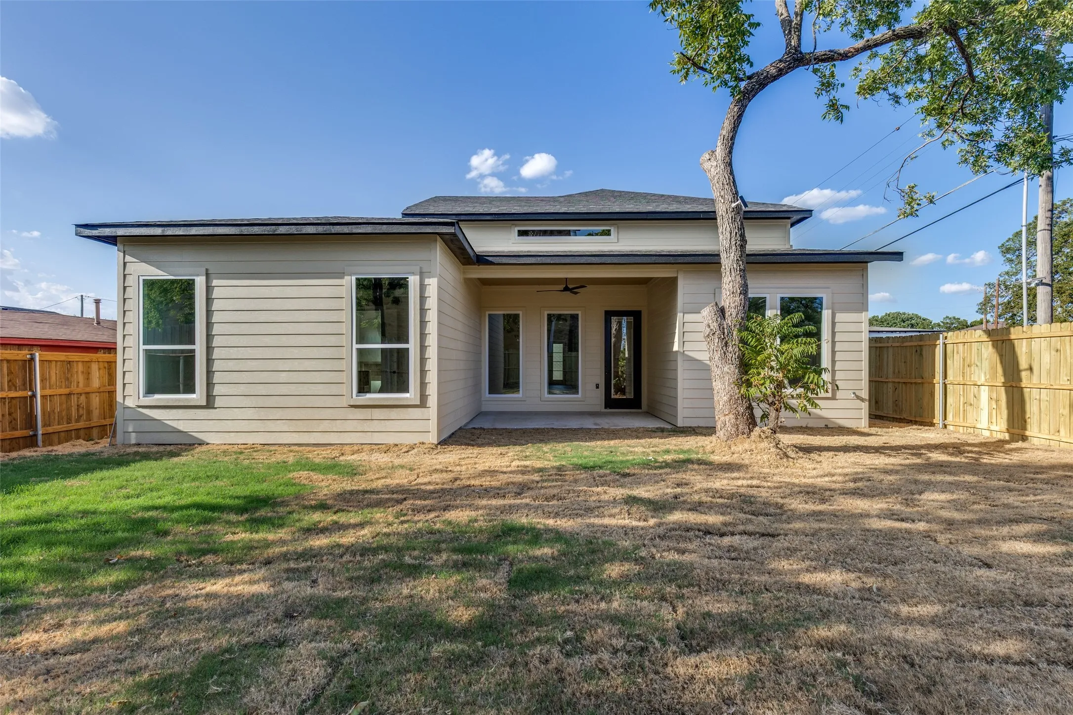 Rear exterior with horizontal siding, a covered patio, and a privacy fence