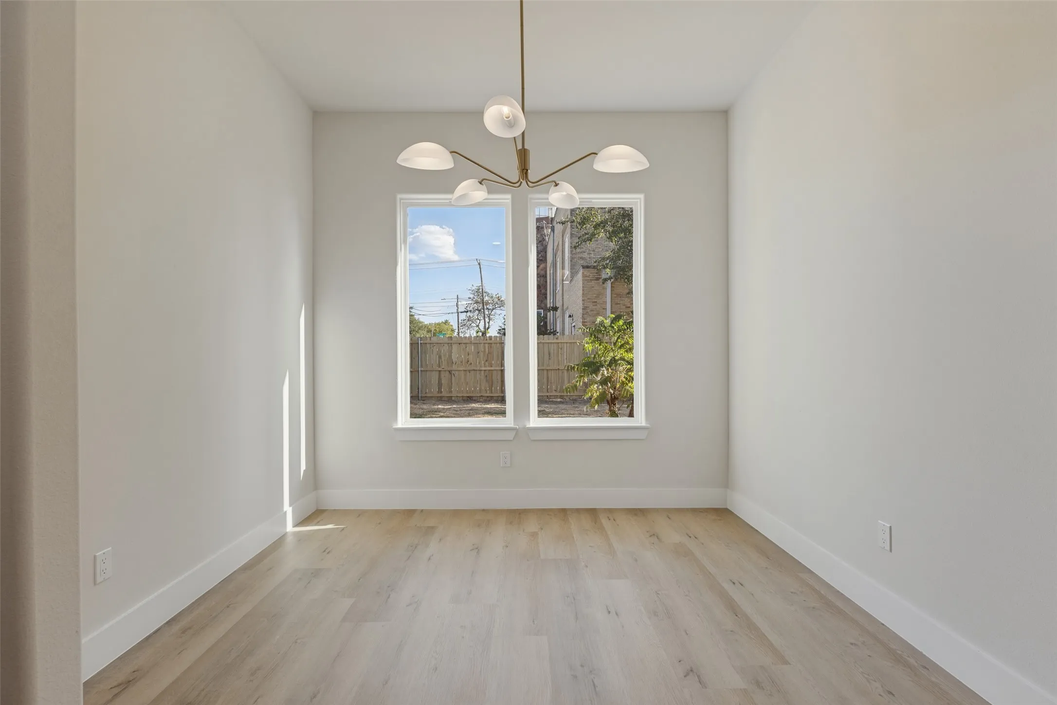 Light-toned wood-finish flooring complements bright white walls