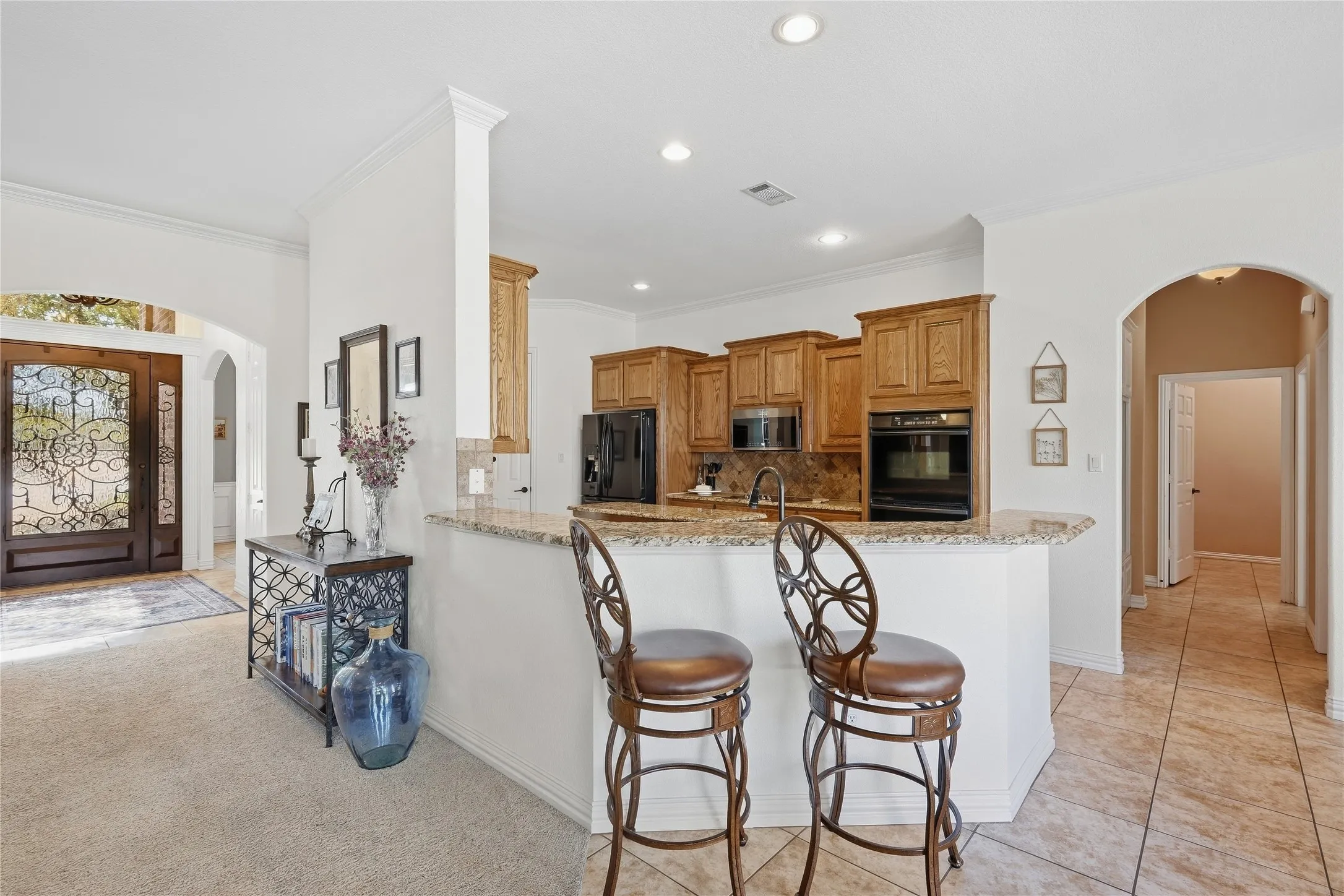 Inviting kitchen with warm wood cabinetry, granite countertops and the breakfast bar has plenty of room for casual dining.