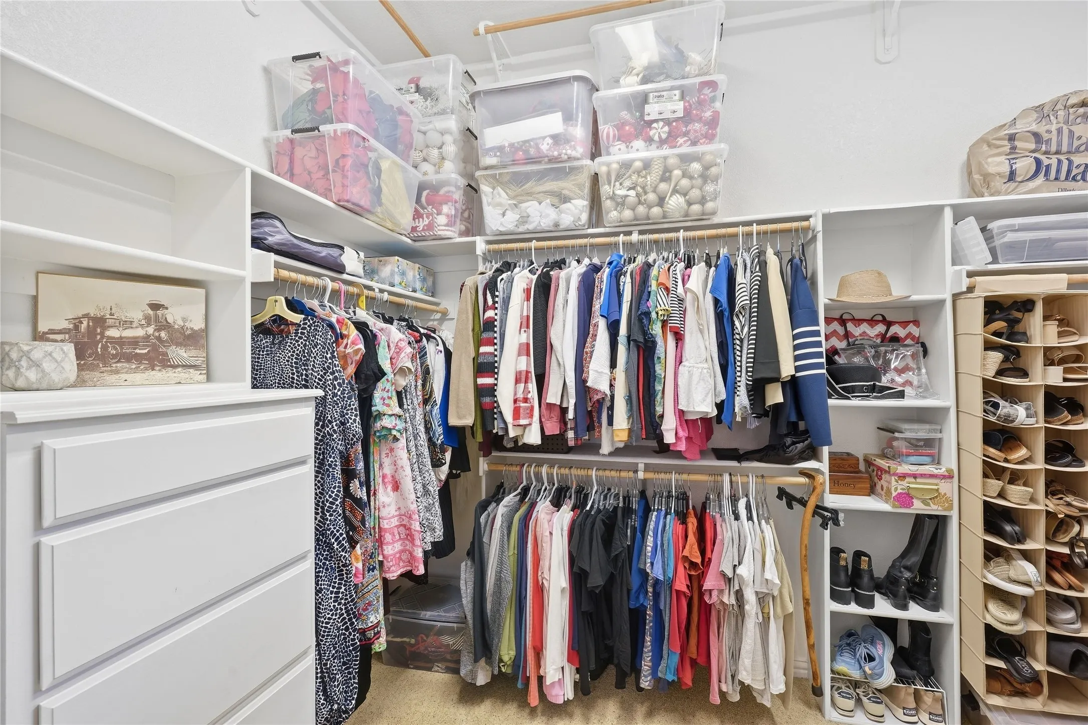 great walk in closet with built ins and lots of shelves up above for storage.
