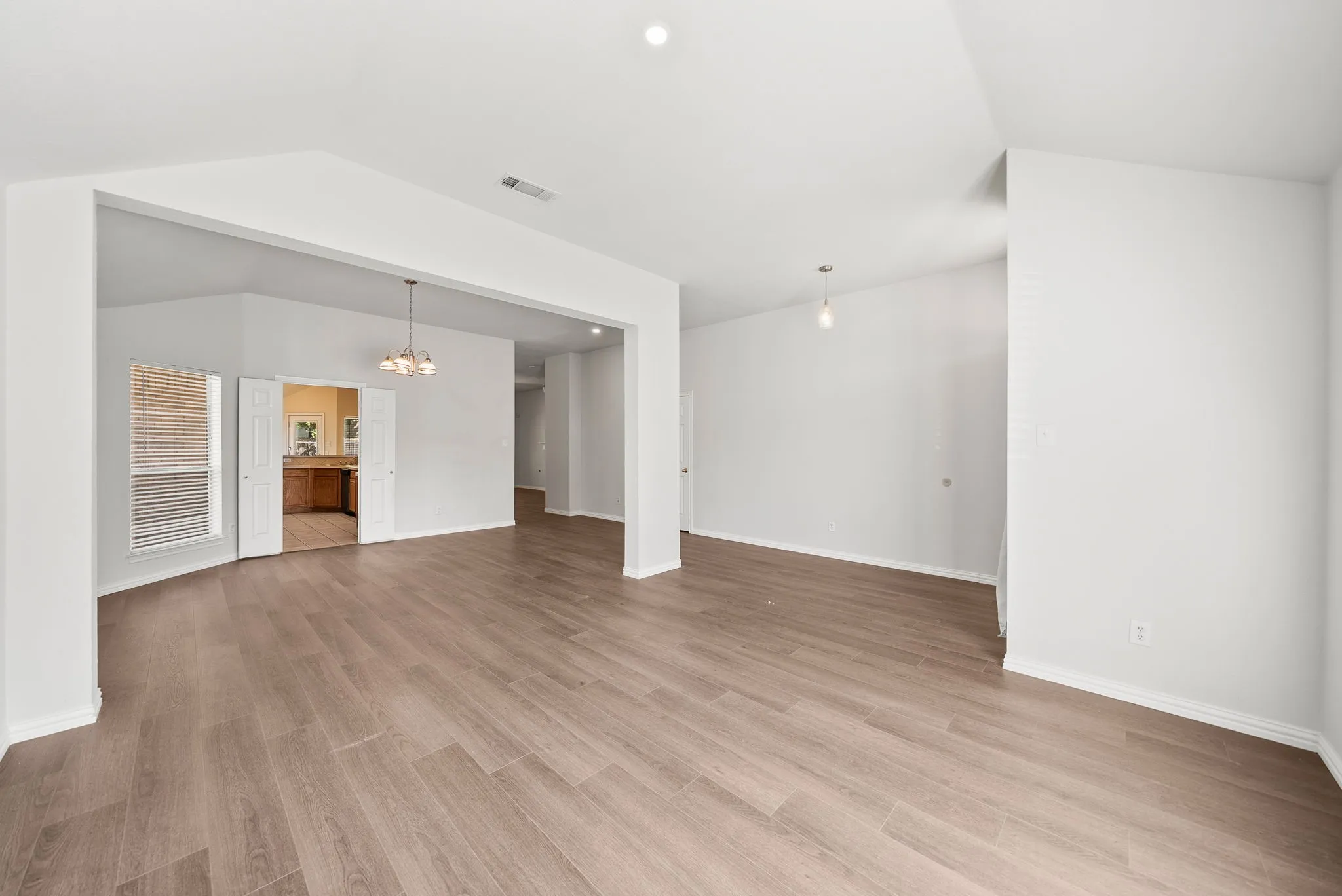 Vaulted ceilings with recessed lighting and pendant fixtures