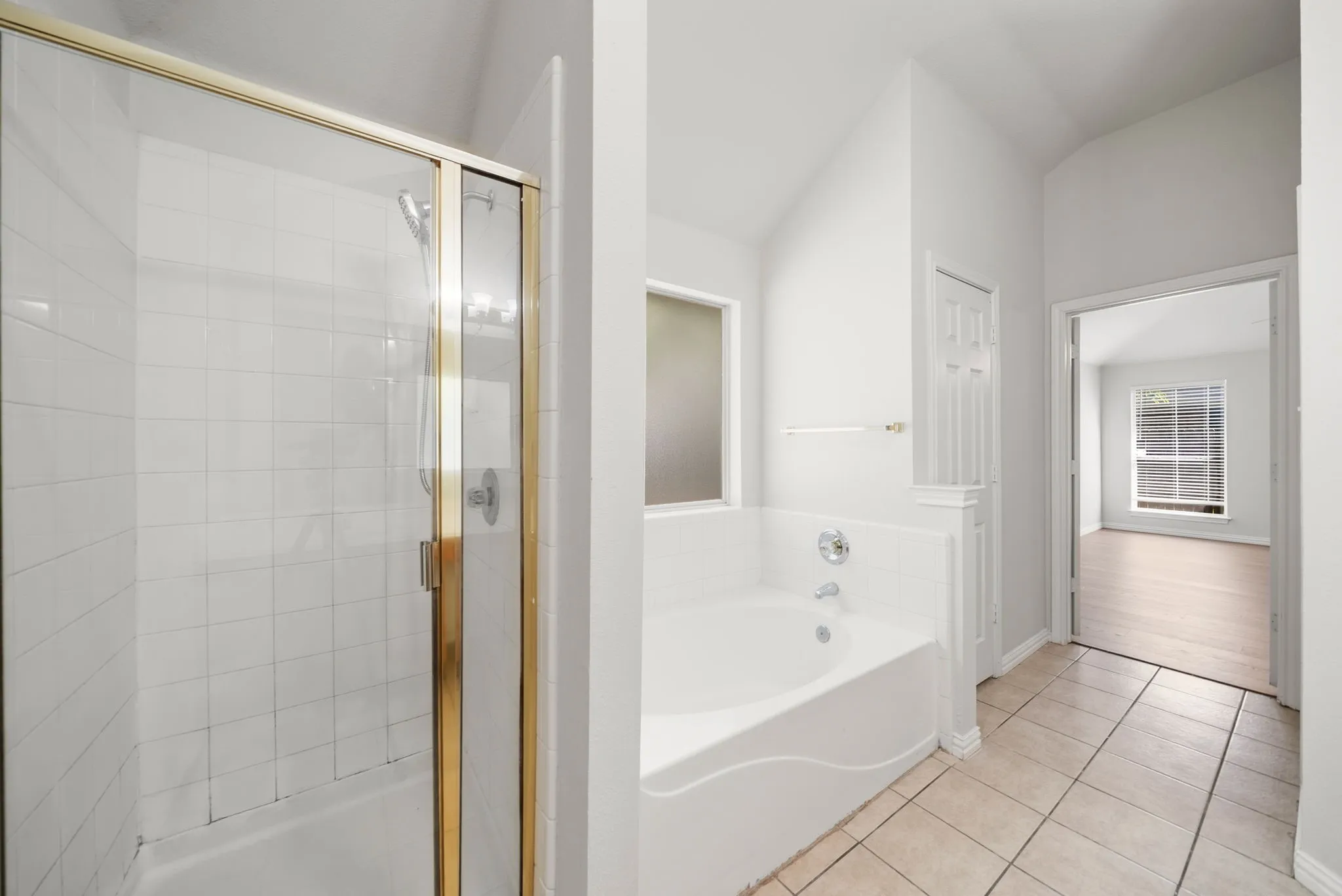Shower with gold-toned framed glass enclosure