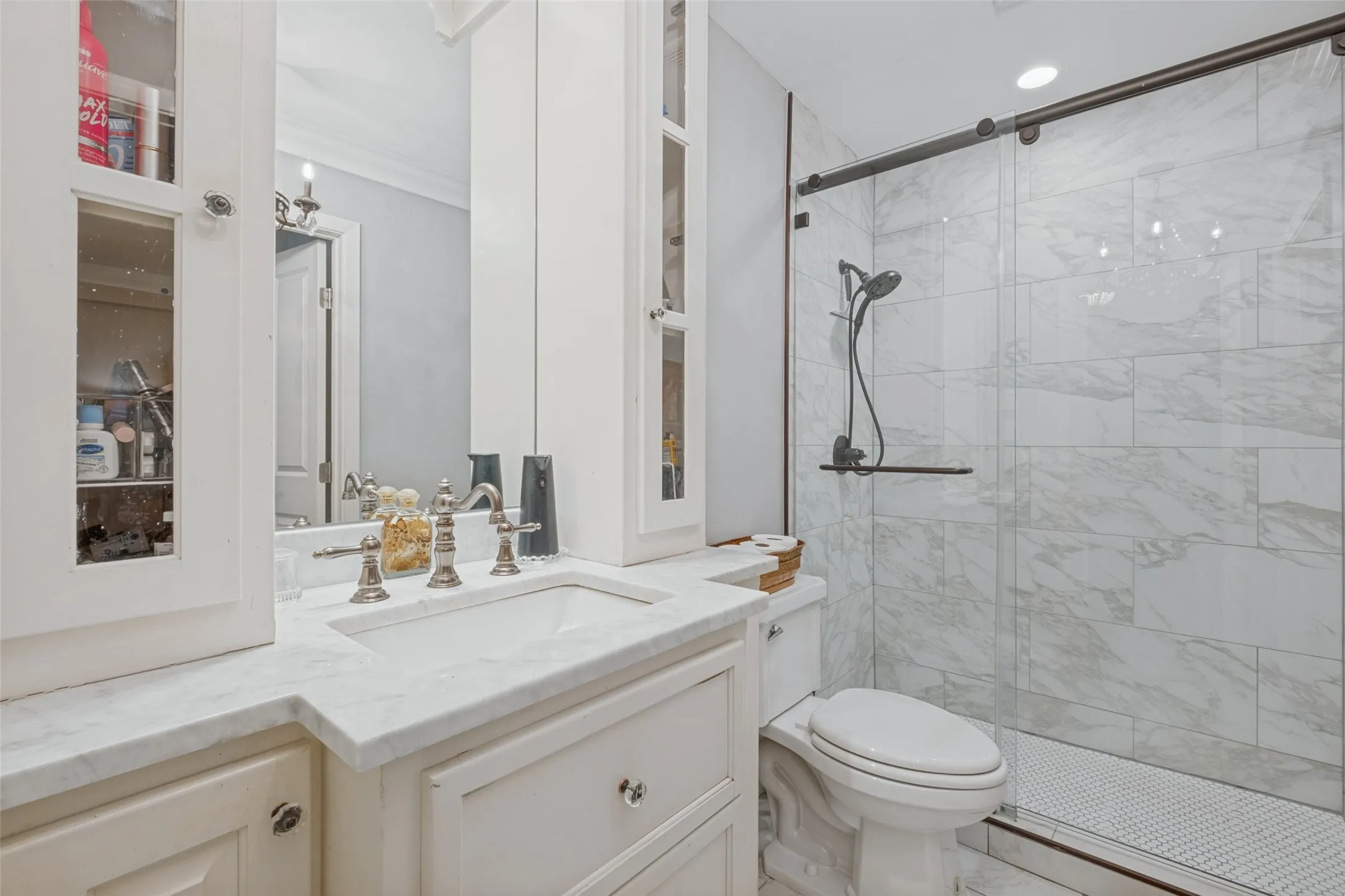Vanity with stone countertop, undermount sink, and wall-mounted mirror