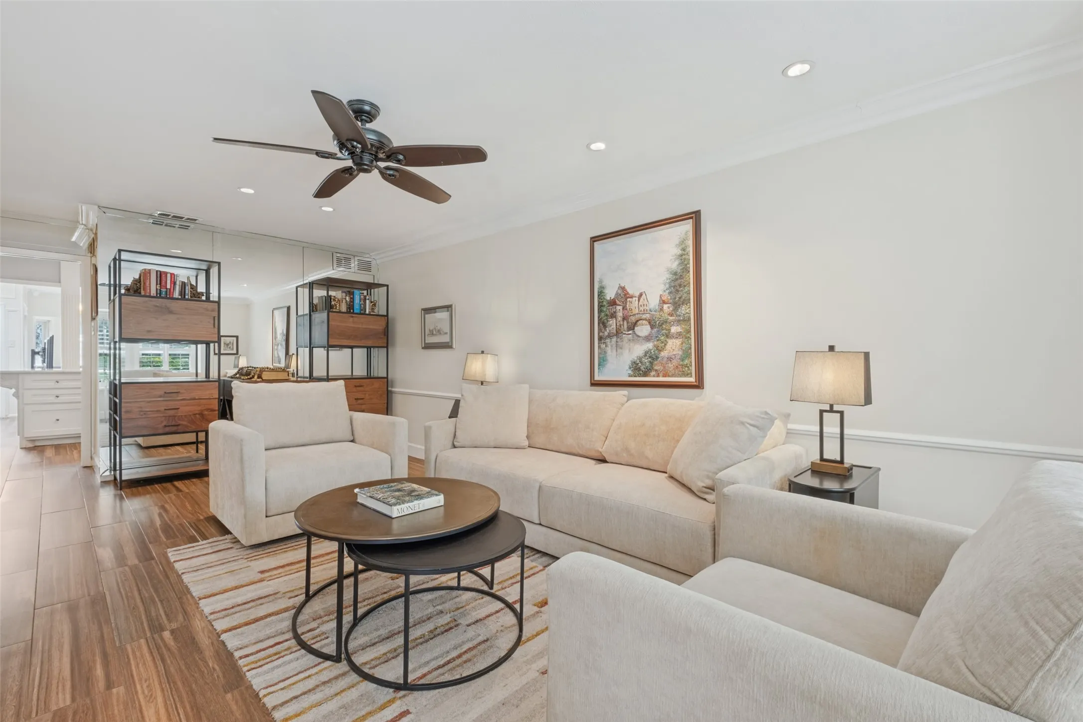 Wood-finish flooring, recessed lighting, crown molding, ceiling fan, and built-in shelving