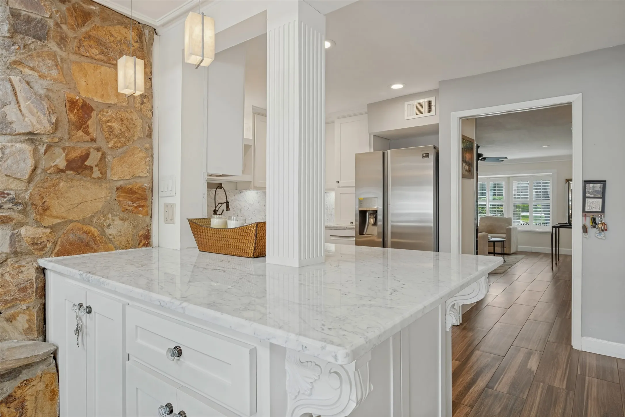 Kitchen island with a light-toned countertop and white cabinetry