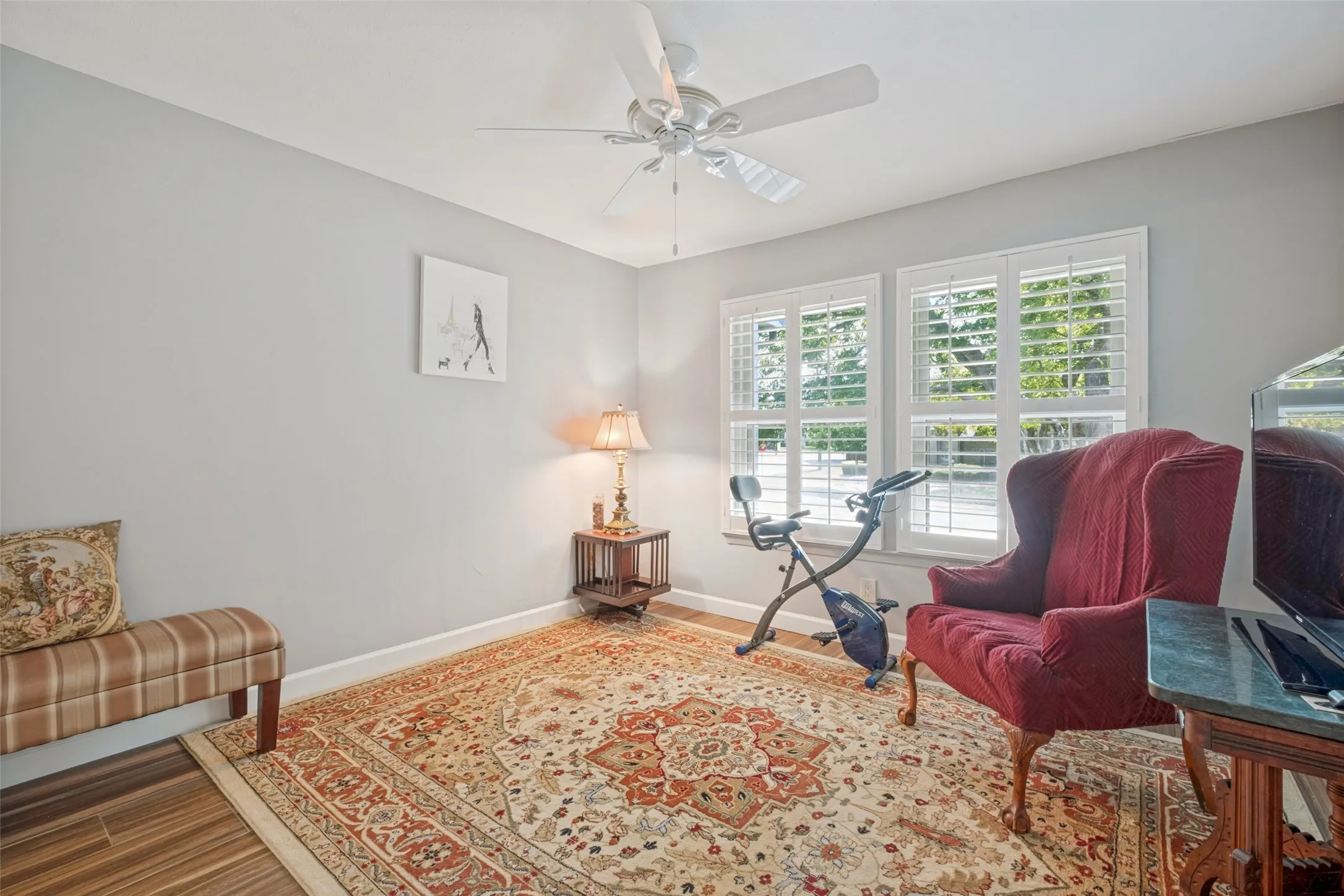 Wood-finish flooring, light gray walls, and a ceiling fan