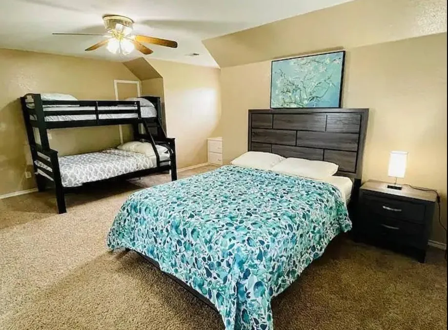 Carpeted room featuring a ceiling fan with light kit and sloped ceiling